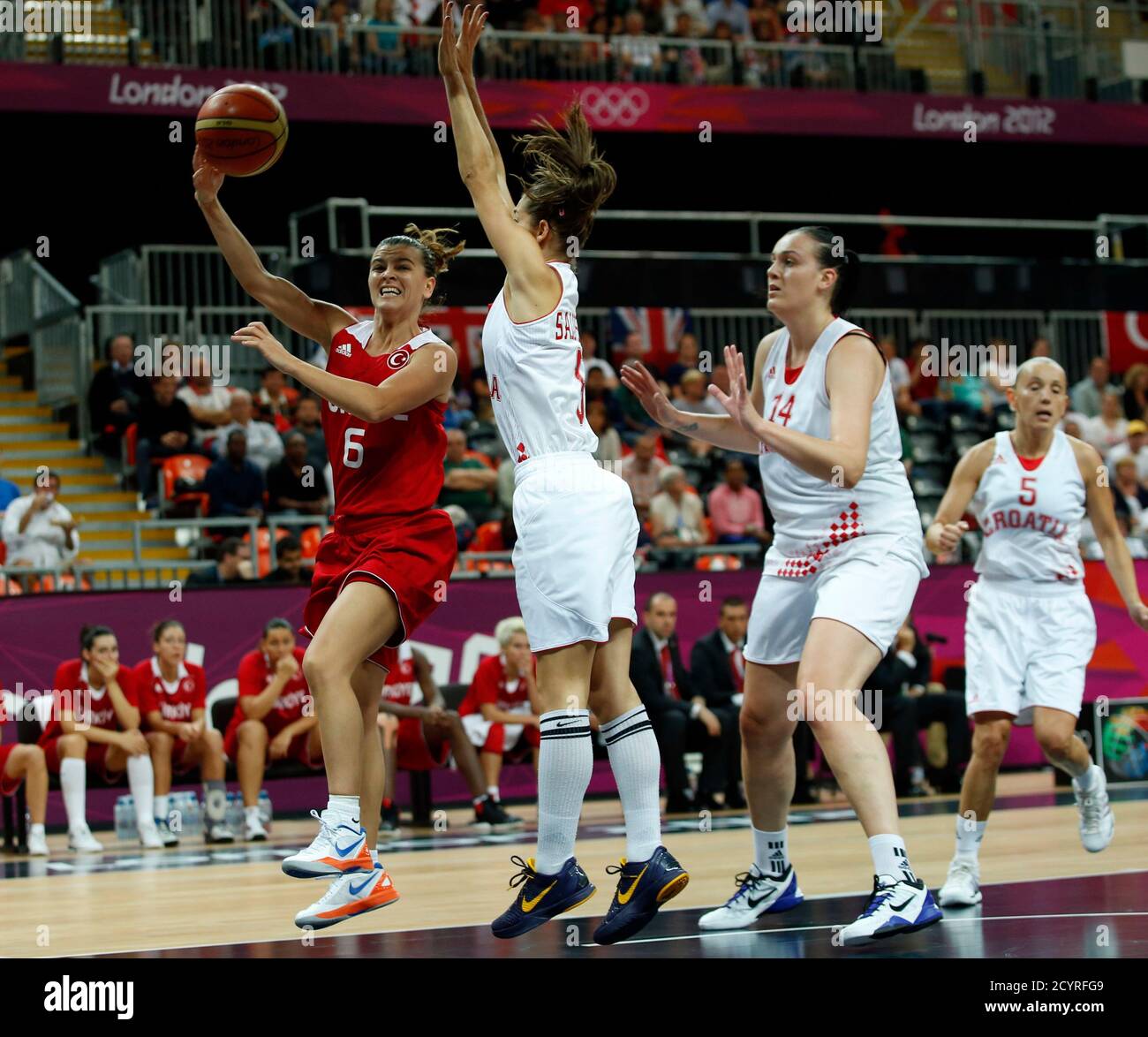 Turkey's Birsel Vardarli (L) makes a pass around Croatia's Emanuela Salopek  (C) and Luca Ivankovic during their women's preliminary round Group A  basketball match at the Basketball Arena during the London 2012