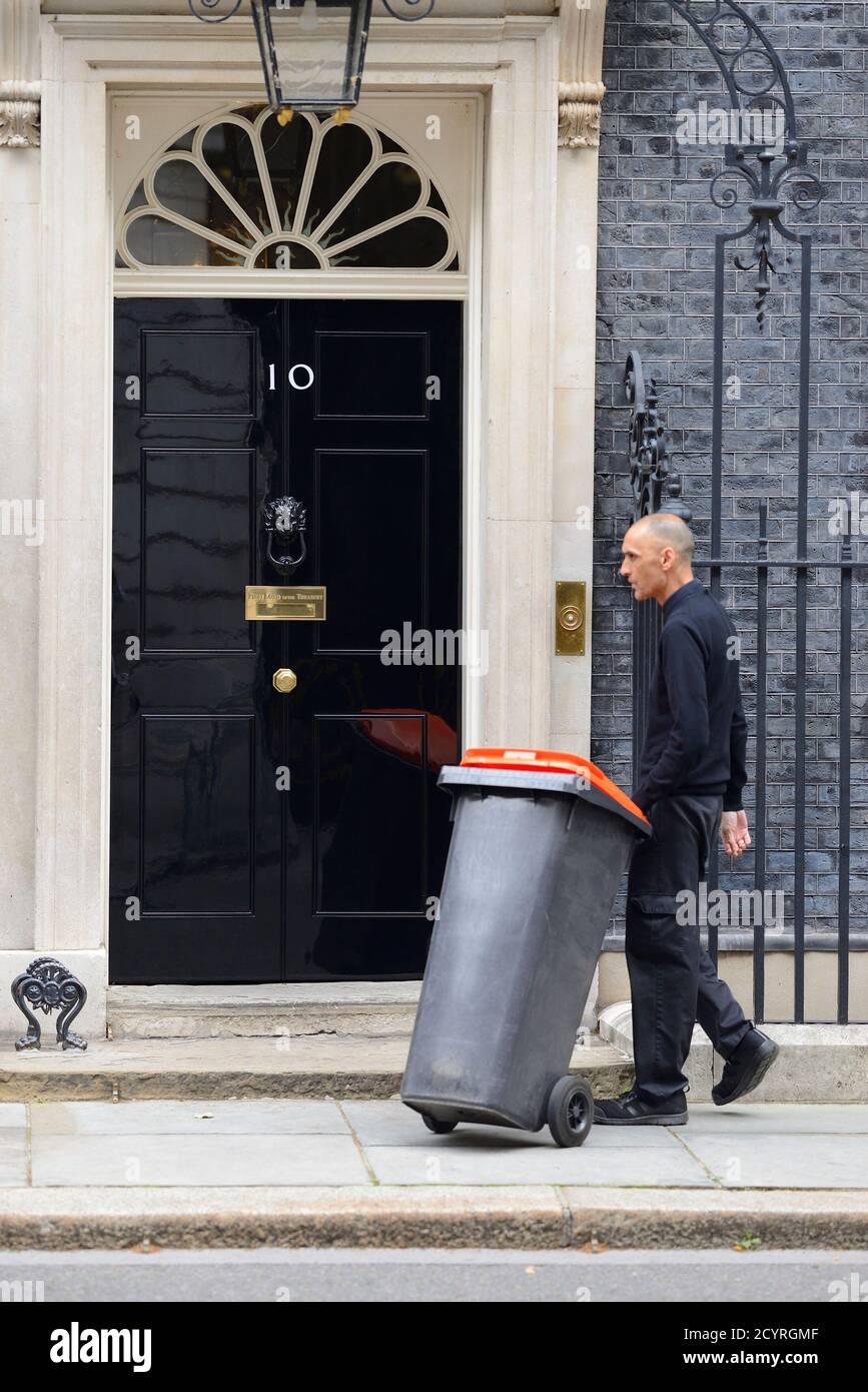 London, England, UK. Bin man with a wheelie bin in Downing Street Stock Photo