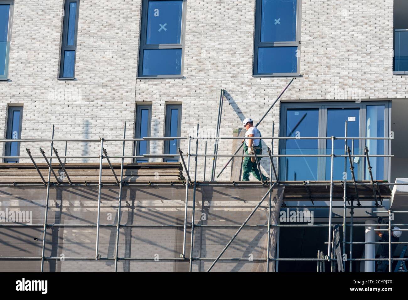 Building / dismantling scaffolding by construction worker for a new construction project Stock Photo