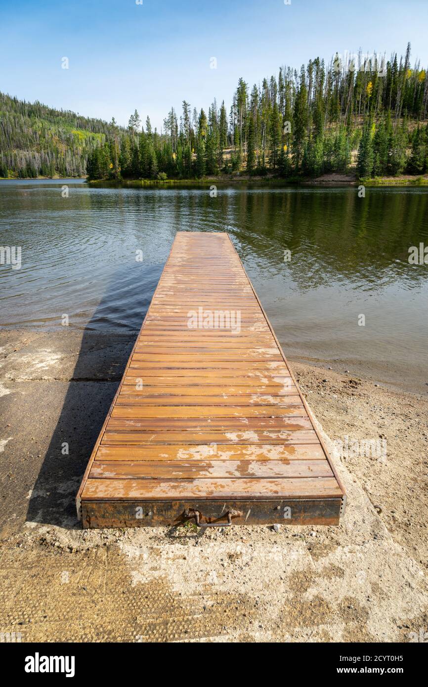 An empty wood boat dock leads into Pearl Lake in Clark, Colorado Stock Photo