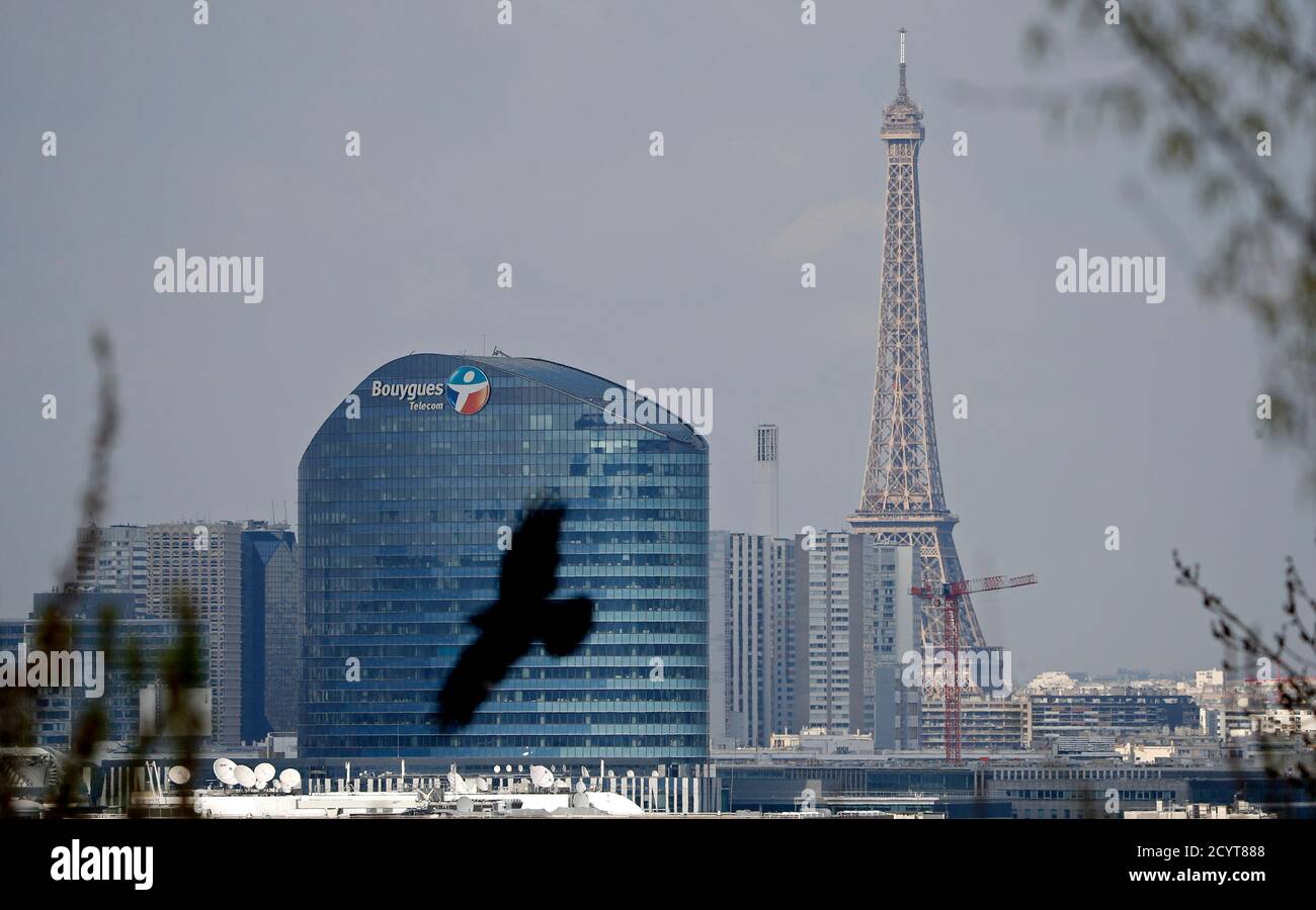 A Bouygues Telecom company logo is seen on the facade of the Sequana tower,  the company's headquarters, in Issy-Les-Moulineaux, near Paris, as the  Eiffel Tower appears in the background, April 6, 2015.
