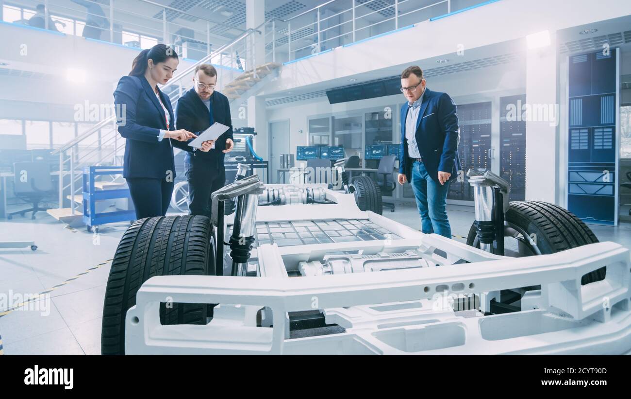 Automotive Design Engineers Talking while Working on Electric Car ...