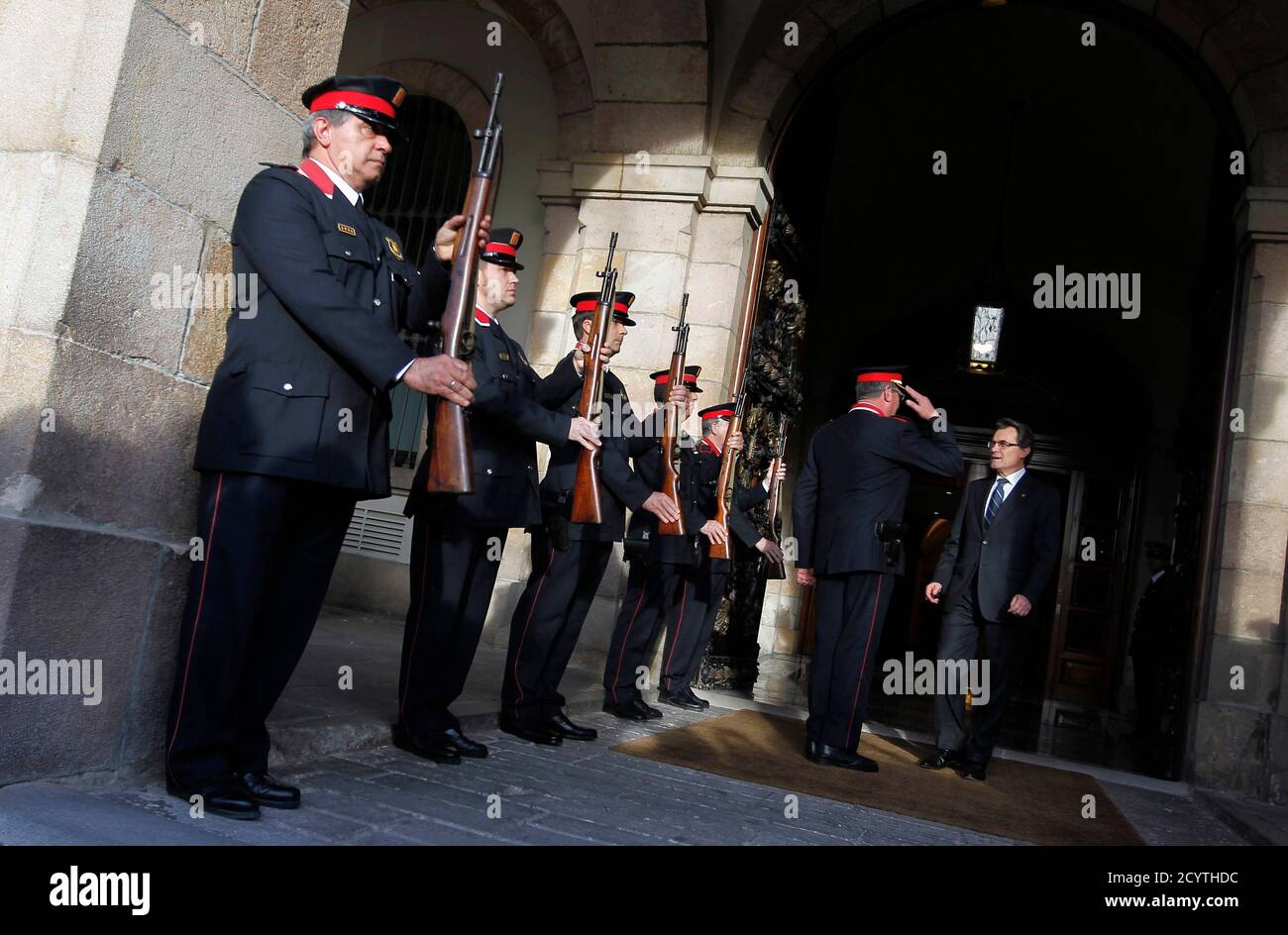 Newly elected President of the Generalitat de Catalunya Artur Mas (CIU party) is saluted by Mossos d'Escuadra (Catalan regional police) as he leaves the Parliament in Barcelona, December 21, 2012.  The leaders of Catalonia's two biggest political forces, CiU and the radical Republican Left, or ERC, signed a pact on Wednesday to overcome their enormous divide on economic and social issues and defy Madrid by holding a referendum on secession from Spain in 2014. REUTERS/Albert Gea (SPAIN - Tags: POLITICS ELECTIONS) Stock Photo