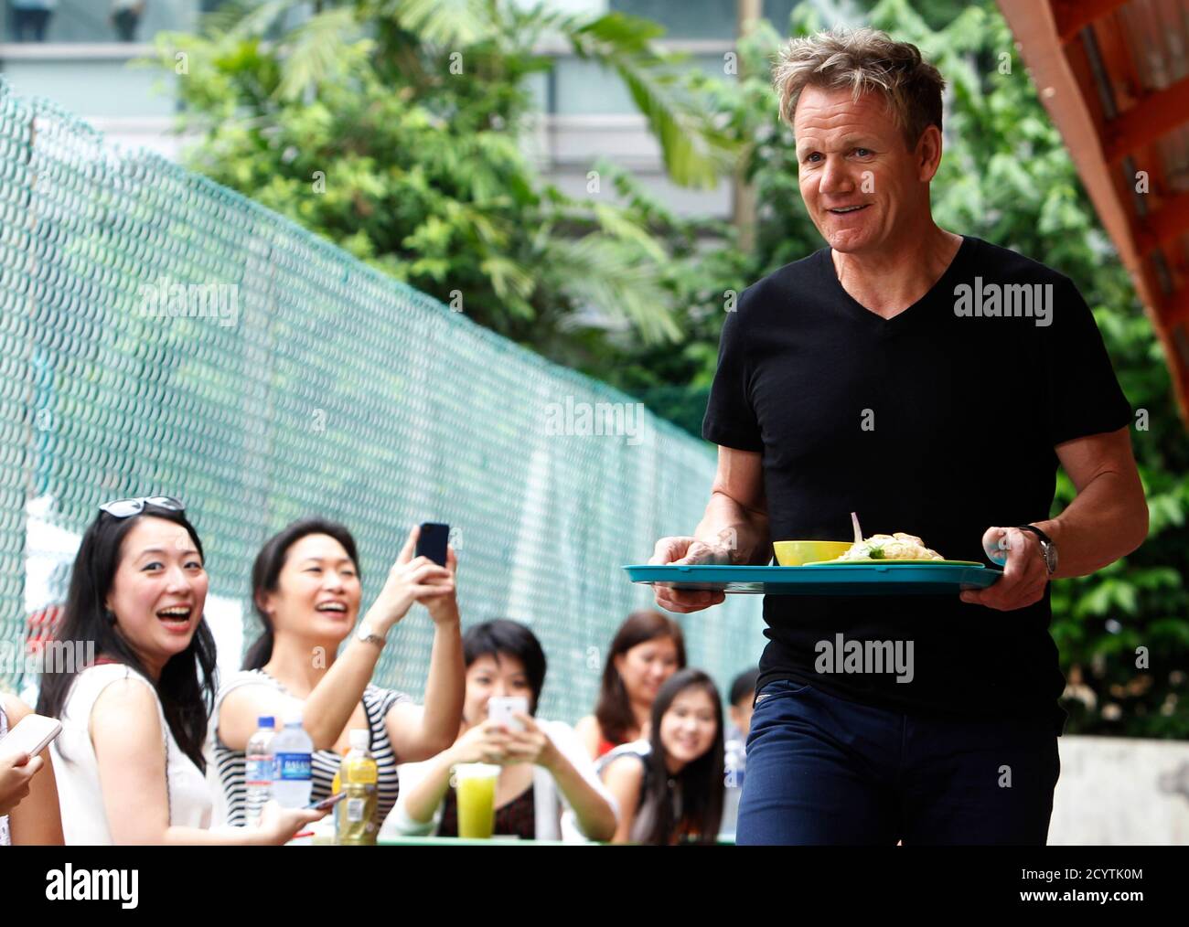 Fans Take Photos Of British Celebrity Chef Gordon Ramsay As He Brings A Plate Of Chicken Rice To His Table At A Food Center In Singapore July 5 2013 Ramsay Was At