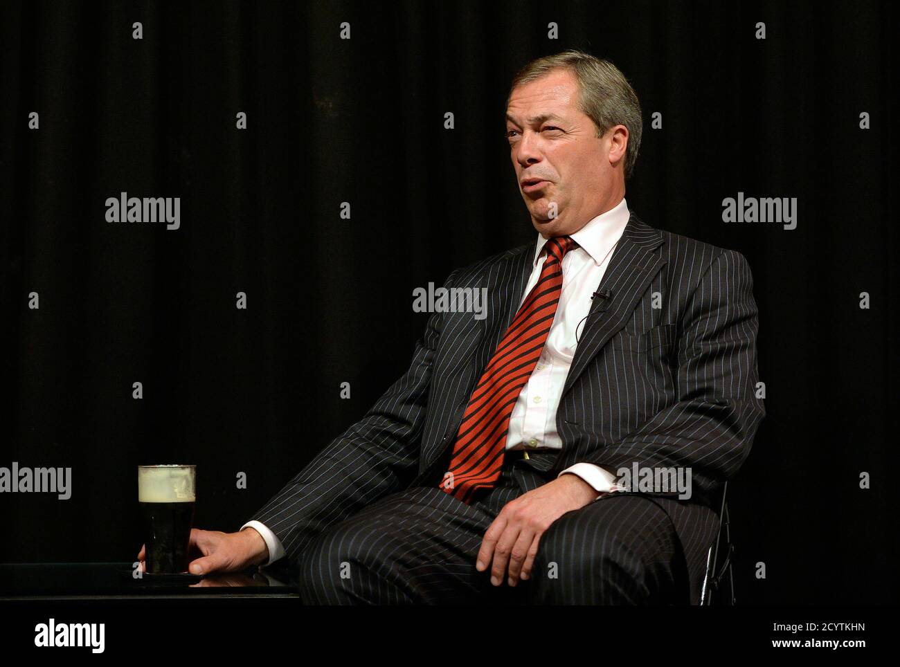 Leader of the UK Independence Party (UKIP) Nigel Farage drinks a pint of stout ale whilst speaking at a question and answer session in Manchester, northern England, September 30, 2013. REUTERS/Toby Melville (BRITAIN - Tags: POLITICS) Stock Photo