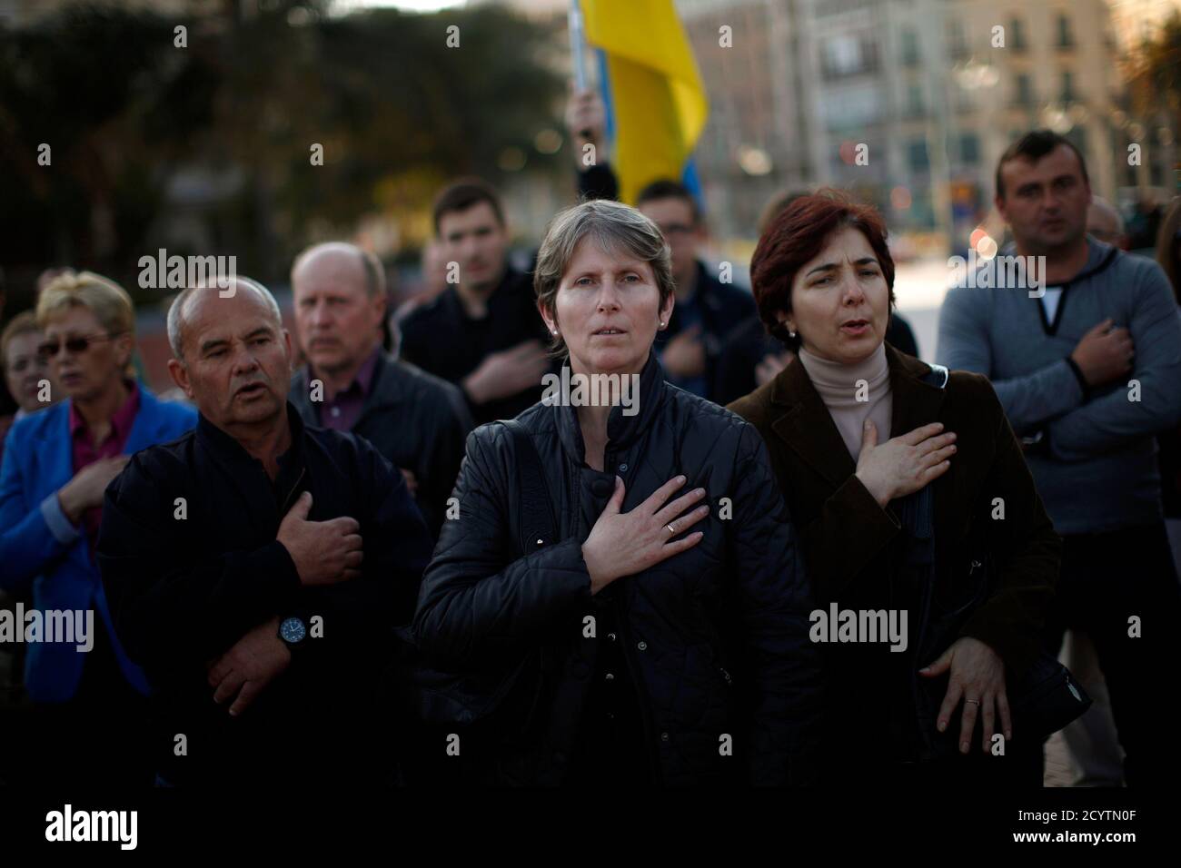 Ukrainians living in Malaga sing the Ukrainian anthem during a protest against Russian President Vladimir Putin and in favor of unity and democratic freedom in Ukraine, in downtown Malaga, southern Spain, March 16, 2014. France on Sunday demanded Russia immediately take measures to reduce 'pointless and dangerous' tensions in Ukraine, calling the secession referendum held in the Crimea region illegal. REUTERS/Jon Nazca (SPAIN - Tags: POLITICS CIVIL UNREST ELECTIONS) Stock Photo