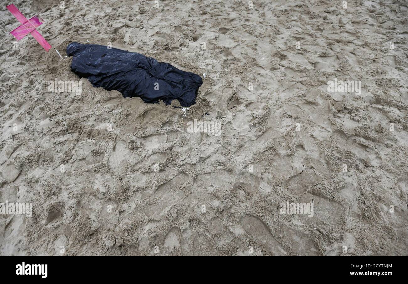 A fake body that representing people which died during police operations in slums during a protest on Copacabana beach in Rio de Janeiro June 10, 2014.  In a project called 'On The Sidelines' Reuters photographers share pictures showing their own quirky and creative view of the 2014 World Cup in Brazil.   REUTERS/Sergio Moraes (BRAZIL) Stock Photo
