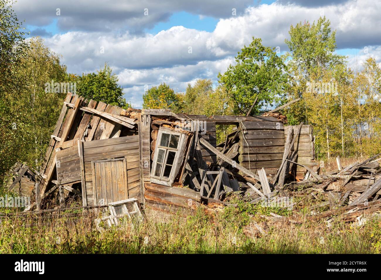 Old wooden broken houses in russian abandoned village in summer day