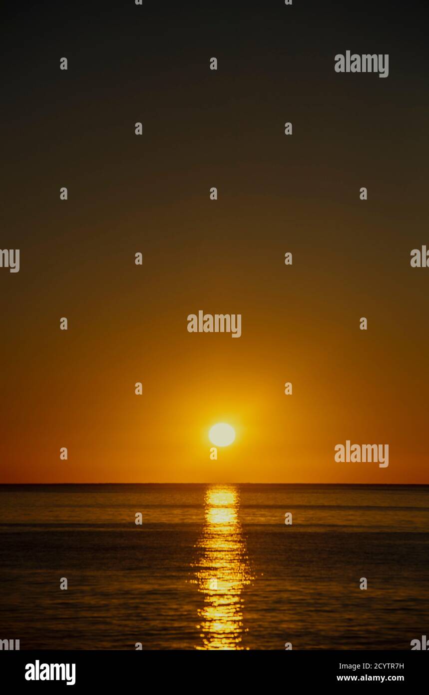 Sun setting over the sea Stock Photo