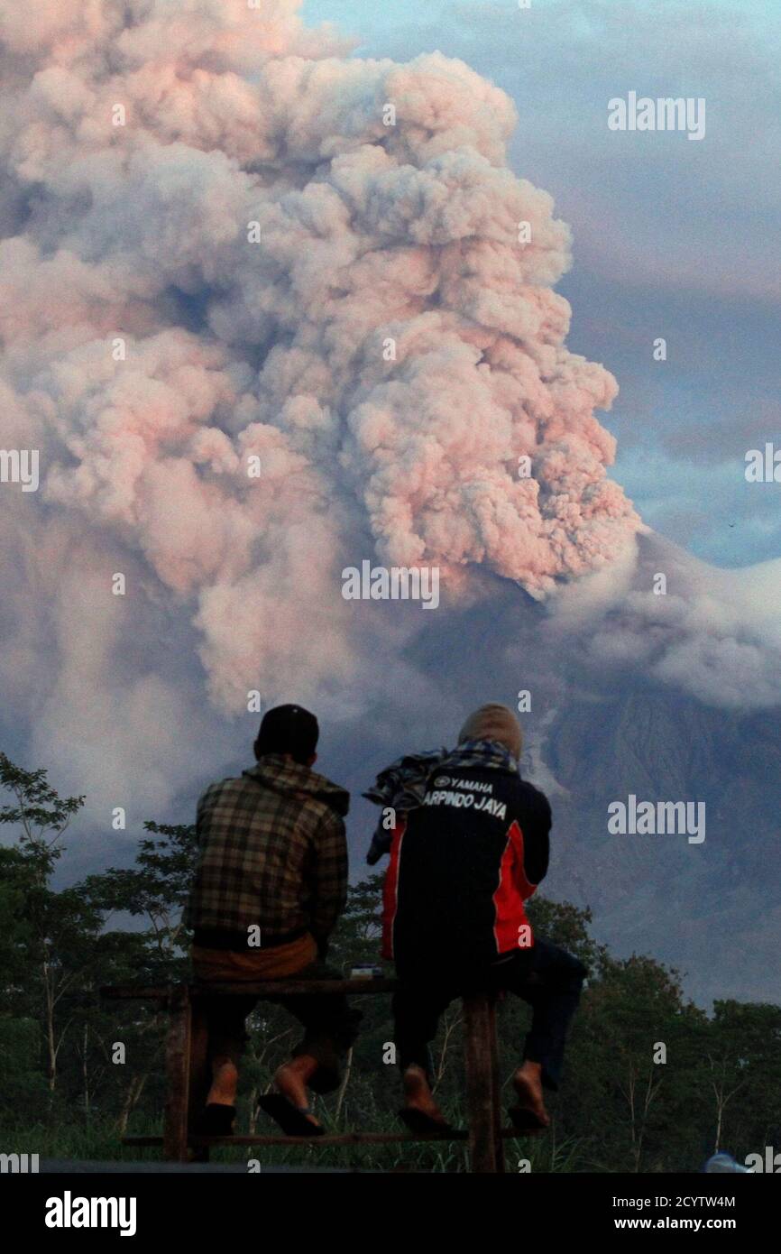 Villagers looks at the eruption of Mount Merapi volcano in Sidorejo village, in the Klaten district of Indonesia's central Java province November 10, 2010. Mount Merapi showed lethargic signs on Wednesday but authorities would not lower down its alert status because of its intense seismic activities, the head of the country's vulcanolology agency said. REUTERS/Andry Prasetyo (INDONESIA - Tags: DISASTER ENVIRONMENT) Stock Photo