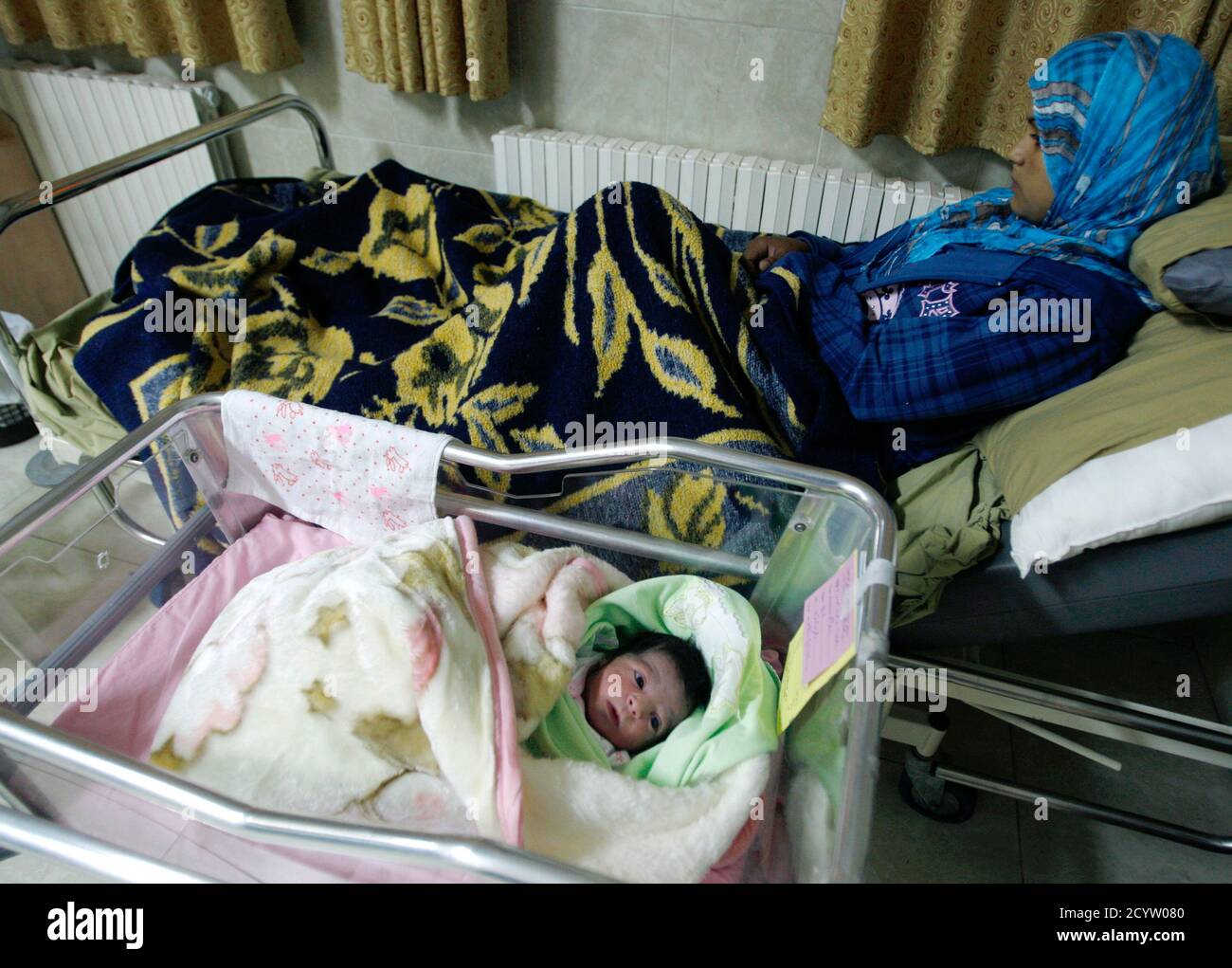 A Newborn Baby Girl Lies Next To Her Mother In The Maternity Ward Of Al Hilal Hospital In The West Bank City Of Ramallah October 30 2011 The World S Population Will Reach Seven