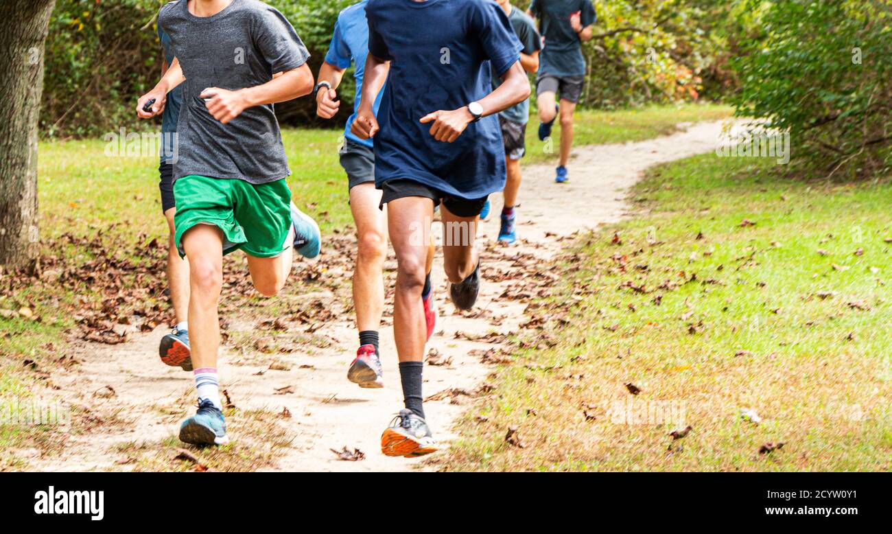 Front view of a group of high school cross country runners running fast