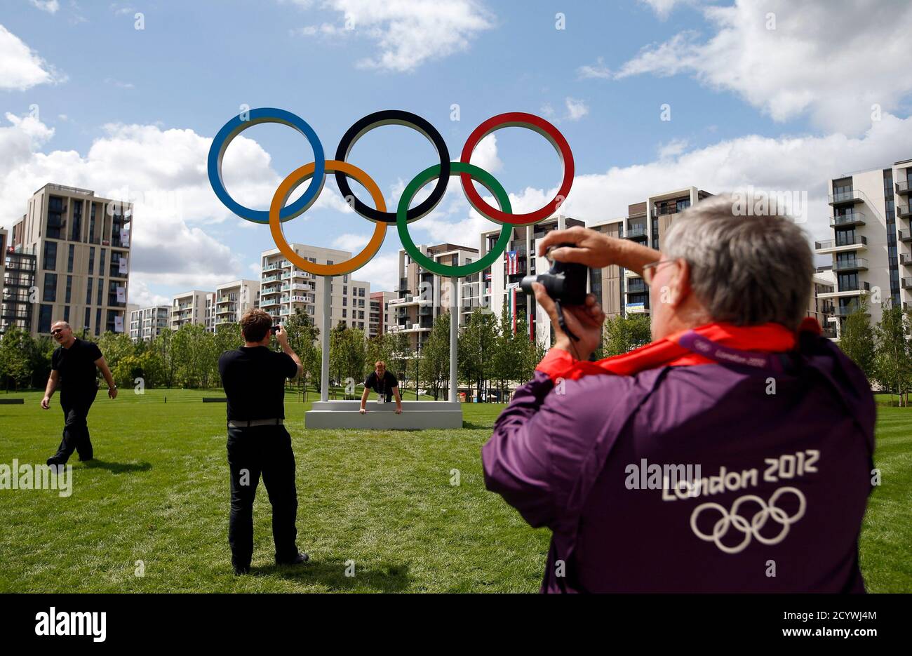 A volunteer takes a photograph of the Olympic rings at the Athletes' Village at the Olympic Park in London, July 19, 2012.  REUTERS/Jae C. Hong/Pool (BRITAIN - Tags: SPORT OLYMPICS) Stock Photo