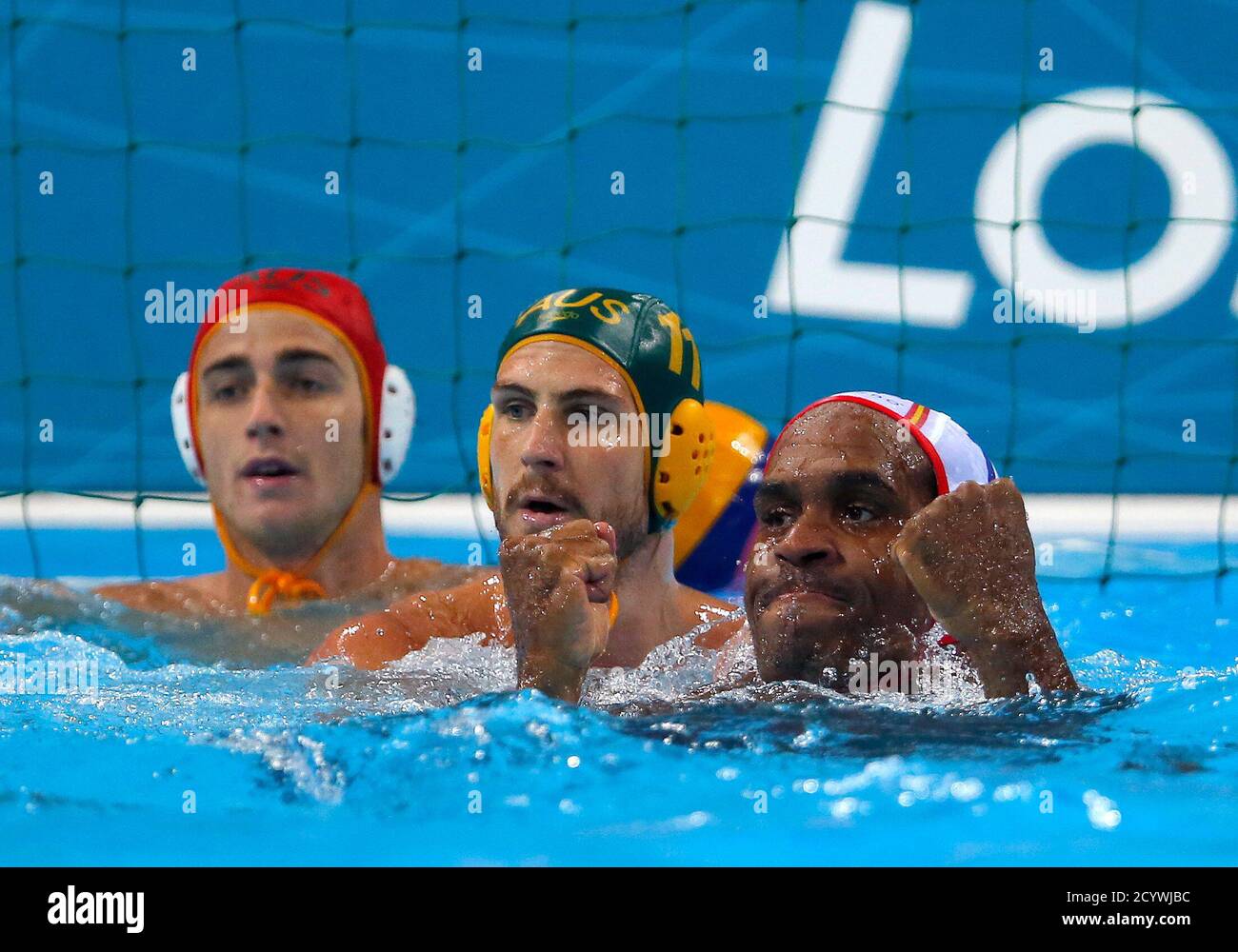 Spain's Ivan Perez Vargas (R) celebrates a goal past Australia's goalkeeper  James Clark (L) and Rhys Howden during their men's preliminary round Group  A water polo match at the London 2012 Olympic