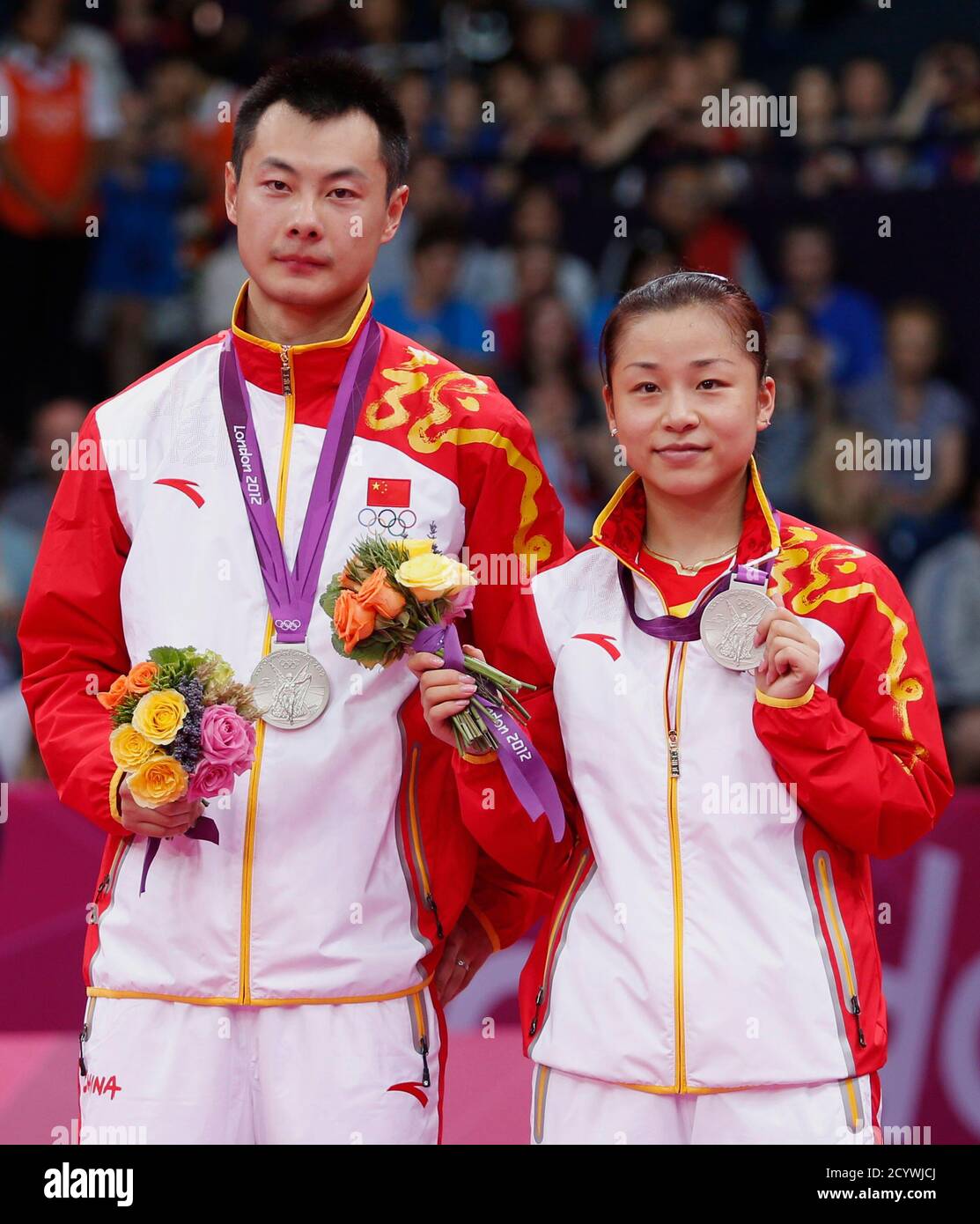 Silver medalists China's Xu Chen (L) and Ma Jin pose for media during the  victory ceremony for the badminton mixed doubles event at the London 2012  Olympic Games at the Wembley Arena