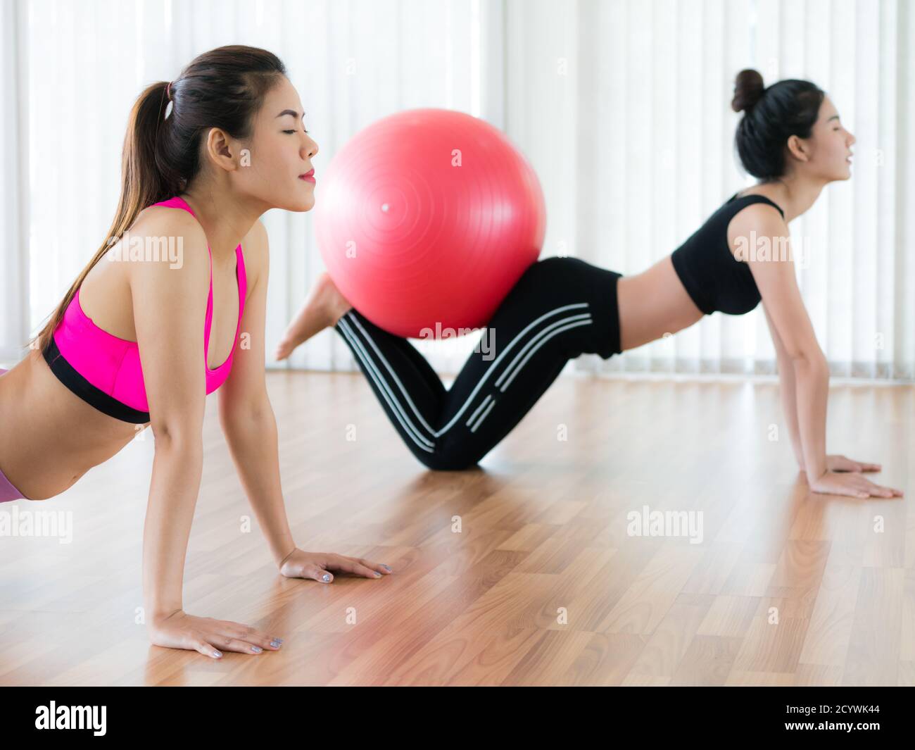 Women doing exercise with fit ball in gym group or yoga class. Healthy lifestyle concept. Stock Photo