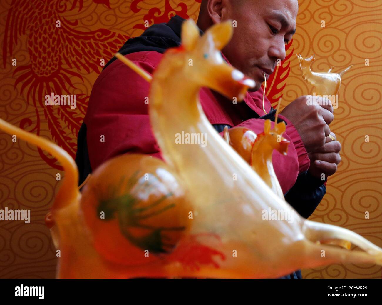 Folk artist Hou Gouyi blows boiled sugar to form the shape of a horse at a temple fair for the traditional Chinese Spring Festival on the third day of the Lunar New Year at Ditan Park, also known as the Temple of Earth, in Beijing February 2, 2014. Sugar sculpture blowing is a traditional Chinese folk art where artists blow and sculpt hot sugar to create three-dimensional figures. The Lunar New Year, or Spring Festival, began on January 31 and marked the start of the Year of the Horse, according to the Chinese zodiac.   REUTERS/Kim Kyung-Hoon (CHINA - Tags: ANNIVERSARY SOCIETY) Stock Photo
