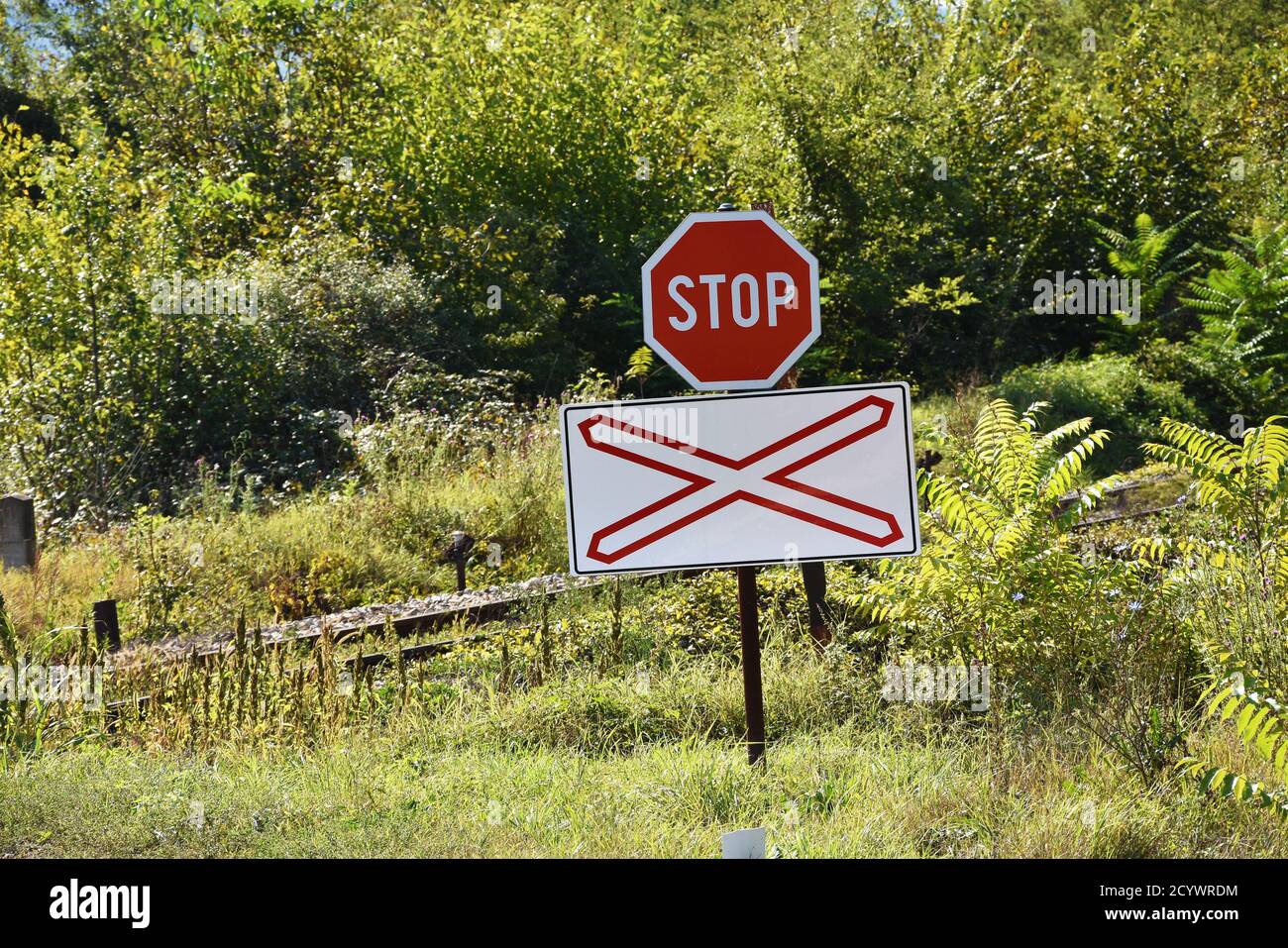 Road signs that war drivers on upcoming rail road crossing without security  bumpers Stock Photo