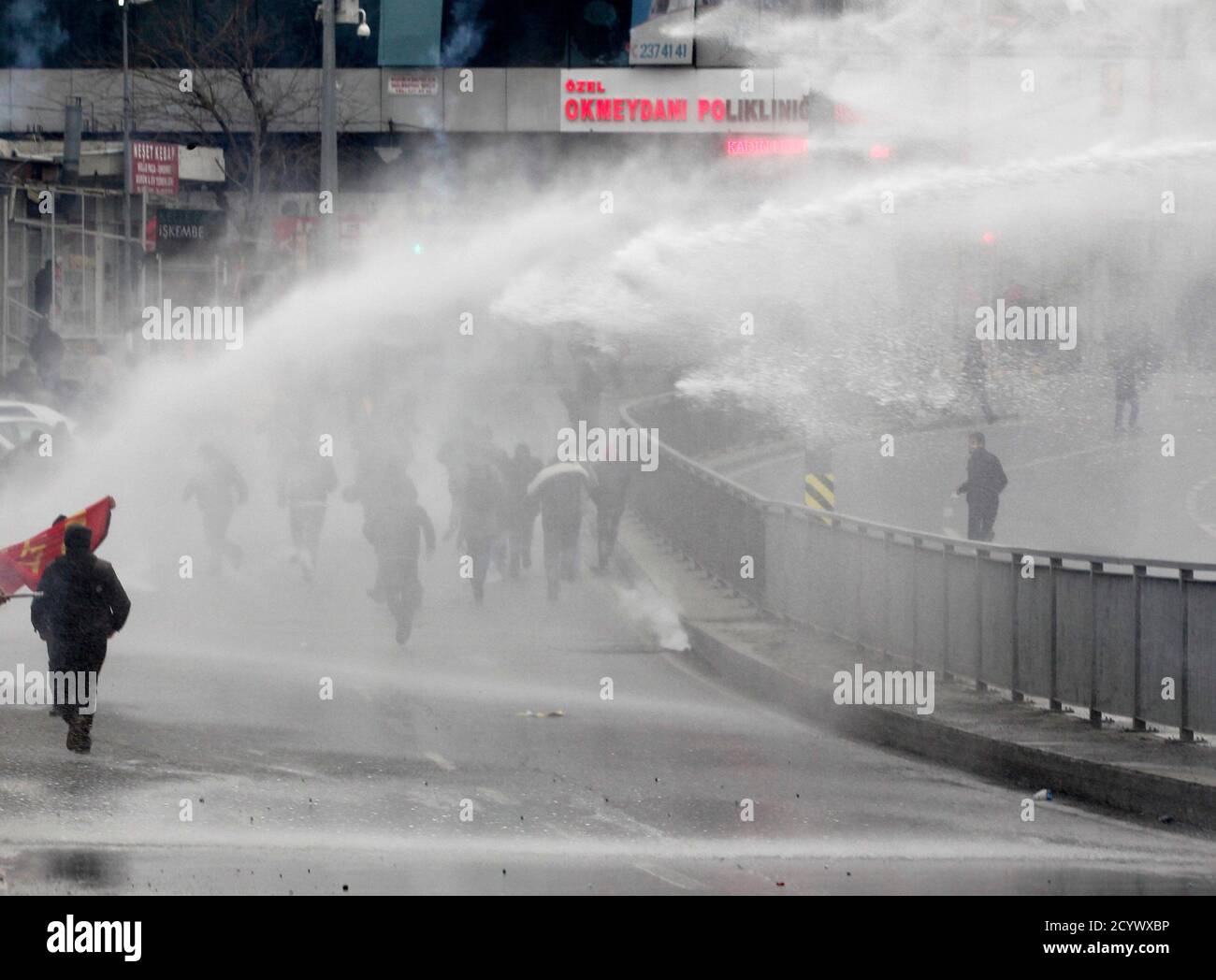Protesters run from water cannons used by riot police to disperse them during a protest march to commemorate the death of Berkin Elvan, in Istanbul March 11, 2015. Riot police fired water cannons to disperse protesters in Istanbul as they marched to mark the anniversary of the death of Elvan, the 15-year-old boy who suffered a head injury during anti-government protests in Istanbul in 2012, dying on March 11, 2013 after spending months in a coma.   REUTERS/Osman Orsal (TURKEY - Tags: POLITICS CIVIL UNREST CRIME LAW) Stock Photo