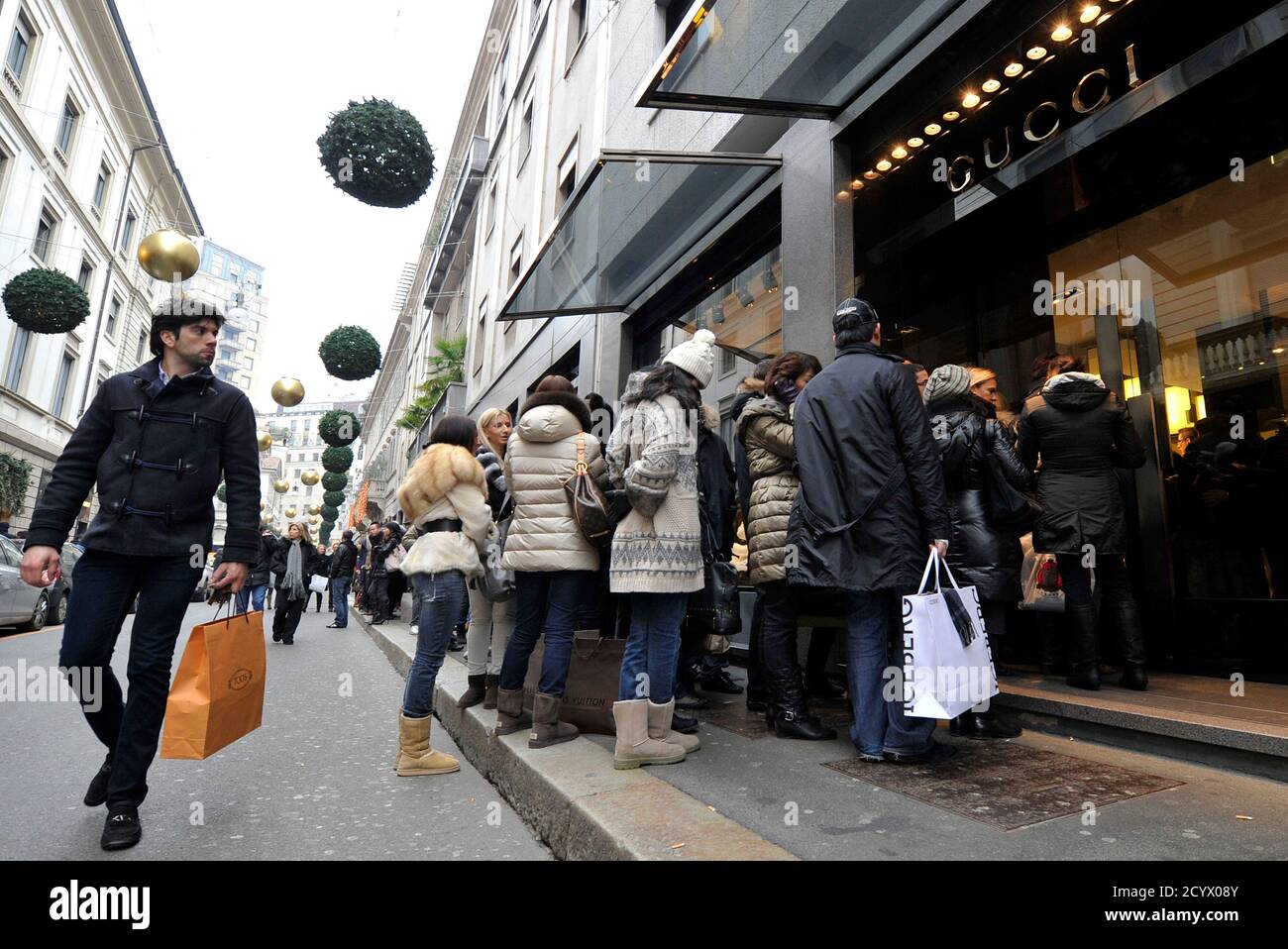 Tegne forsikring At adskille Mesterskab A passer-by (L) looks on as shoppers queue up outside a Gucci shop during  the first day of sales in downtown Milan January 6, 2011. REUTERS/Paolo  Bona (ITALY - Tags: BUSINESS SOCIETY