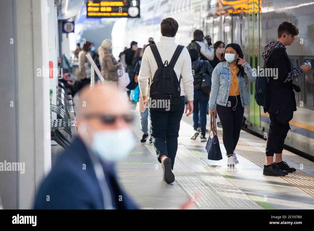 ROME, ITALY - OCTOBER 01 2020: Pedestrians, wearing protective face masks, disembark from a train in Rome, Italy. Stock Photo