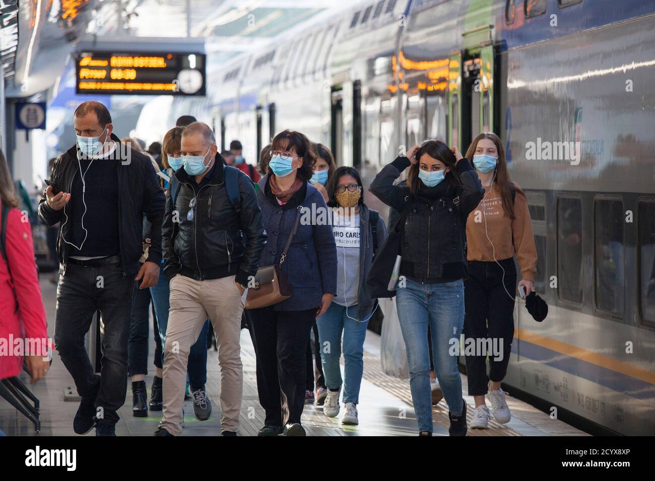 ROME, ITALY - OCTOBER 01 2020: Pedestrians, wearing protective face masks, disembark from a train in Rome, Italy. Stock Photo