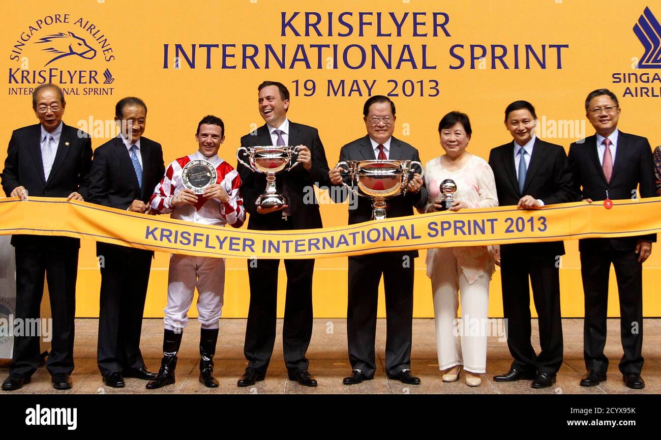 Jockey Brett Prebble (3rd L) celebrates with trainer Casper Fownes, horse owner Chung Fuk To and Maria Chang Lee Ming Shum after Lucky Nine of Hong Kong won the KrisFlyer International Sprint horse race at the Singapore Turf Club May 19, 2013. REUTERS/Edgar Su (SINGAPORE - Tags: SPORT HORSE RACING) Stock Photo