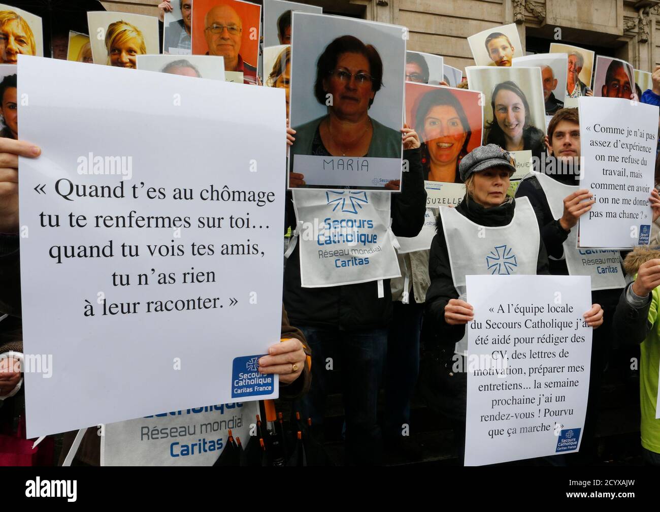 Members of the charity organization Secours Catholique hold portraits of jobless and precarious people during a demonstration against precariousness on the steps of the Opera in Lille, Northen France, November 7, 2013.    REUTERS/Pascal Rossignol   (FRANCE - Tags: BUSINESS EMPLOYMENT SOCIETY POVERTY) Stock Photo