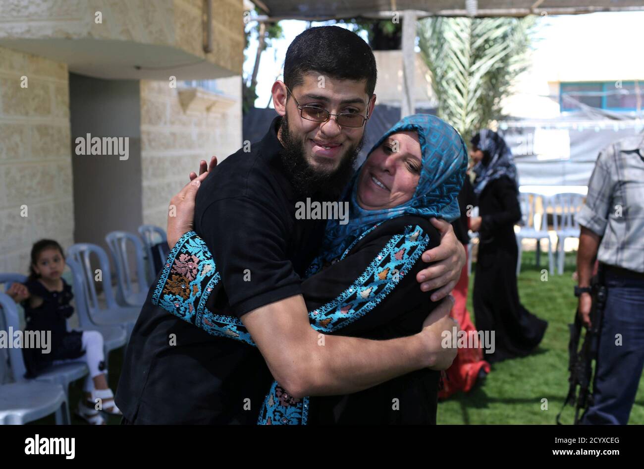 Freed Palestinian prisoner Sayed Harb, 27, hugs his mother upon his release from an Israeli jail, in Khan Younis in the southern Gaza Strip May 26, 2014. According to Harab's family, he served six years in an Israeli jail after being convicted for providing military information on Israeli tanks to the Hamas movement. REUTERS/Ibraheem Abu Mustafa (GAZA - Tags: POLITICS) Stock Photo