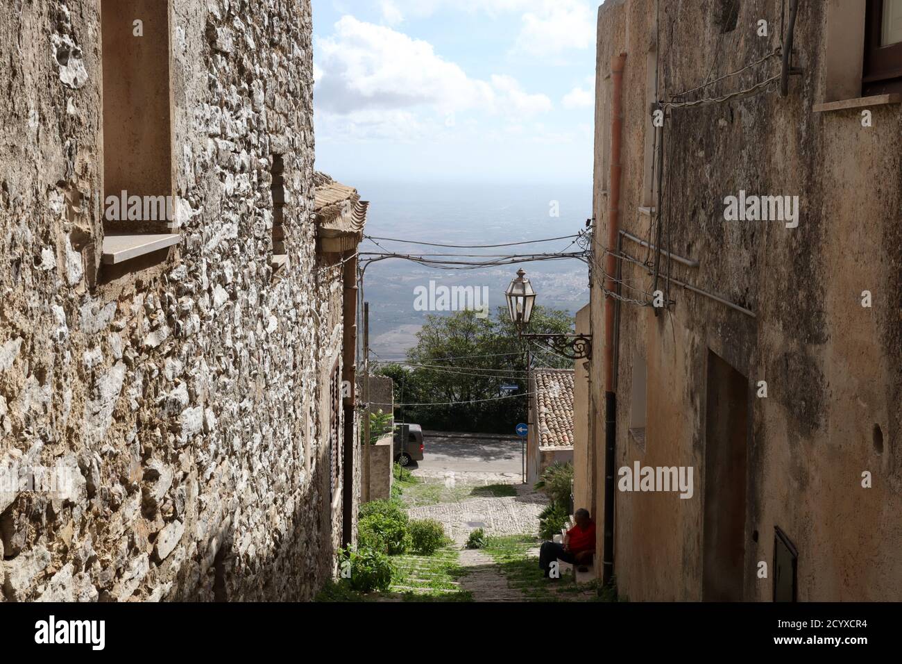 Spectacular view through stone buildings and cobbled streets of valley beyond Erice, Sicily Stock Photo