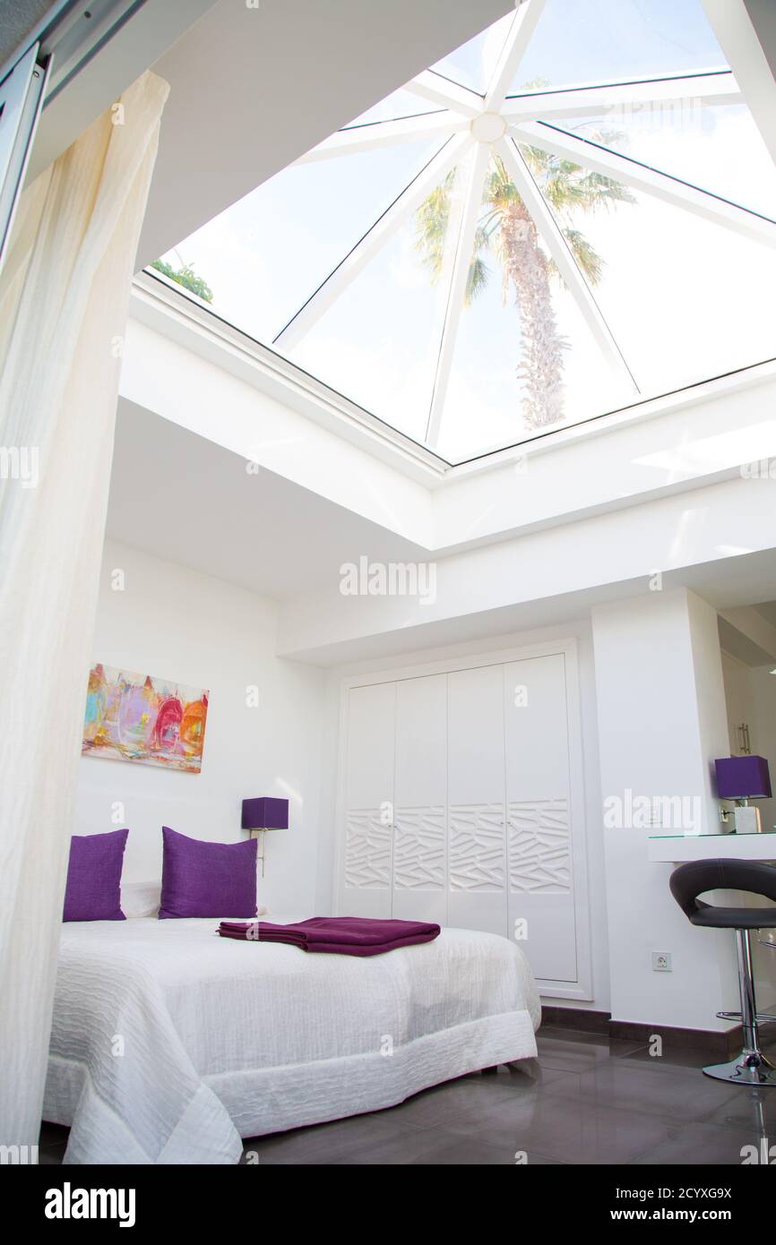 Vertical shot of a beautiful white bedroom interior design with a bed ...