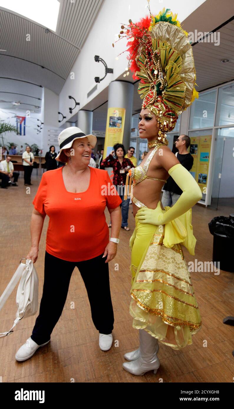 A tourist from the Spanish cruise ship 'Gemini' stands beside a Cuban dancer welcoming visitors at Havana Harbor November 12, 2010. Spanish company Happy Cruises will home-port its 'Gemini' ship in Havana and will offer around-Cuba cruises.  REUTERS/Desmond Boylan (CUBA - Tags: SOCIETY TRAVEL BUSINESS) Stock Photo