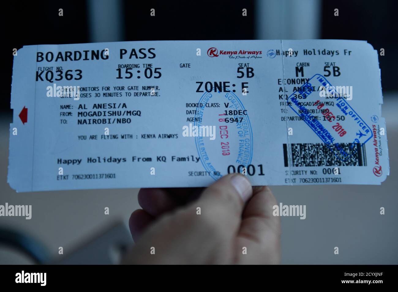 A passenger displays a Kenya Airways boarding pass at Mogadishu
