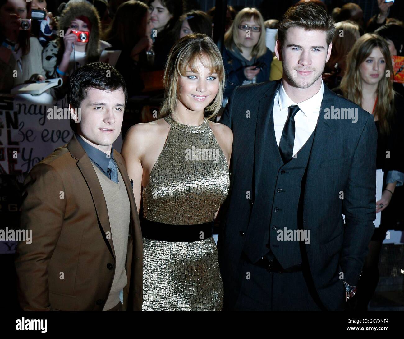 Actors Josh Hutcherson, Jennifer Lawrence and Liam Hemsworth (L-R) pose for  photographers as they arrive for the European premiere of "The Hunger Games"  at the O2 Arena in London March 14, 2012.