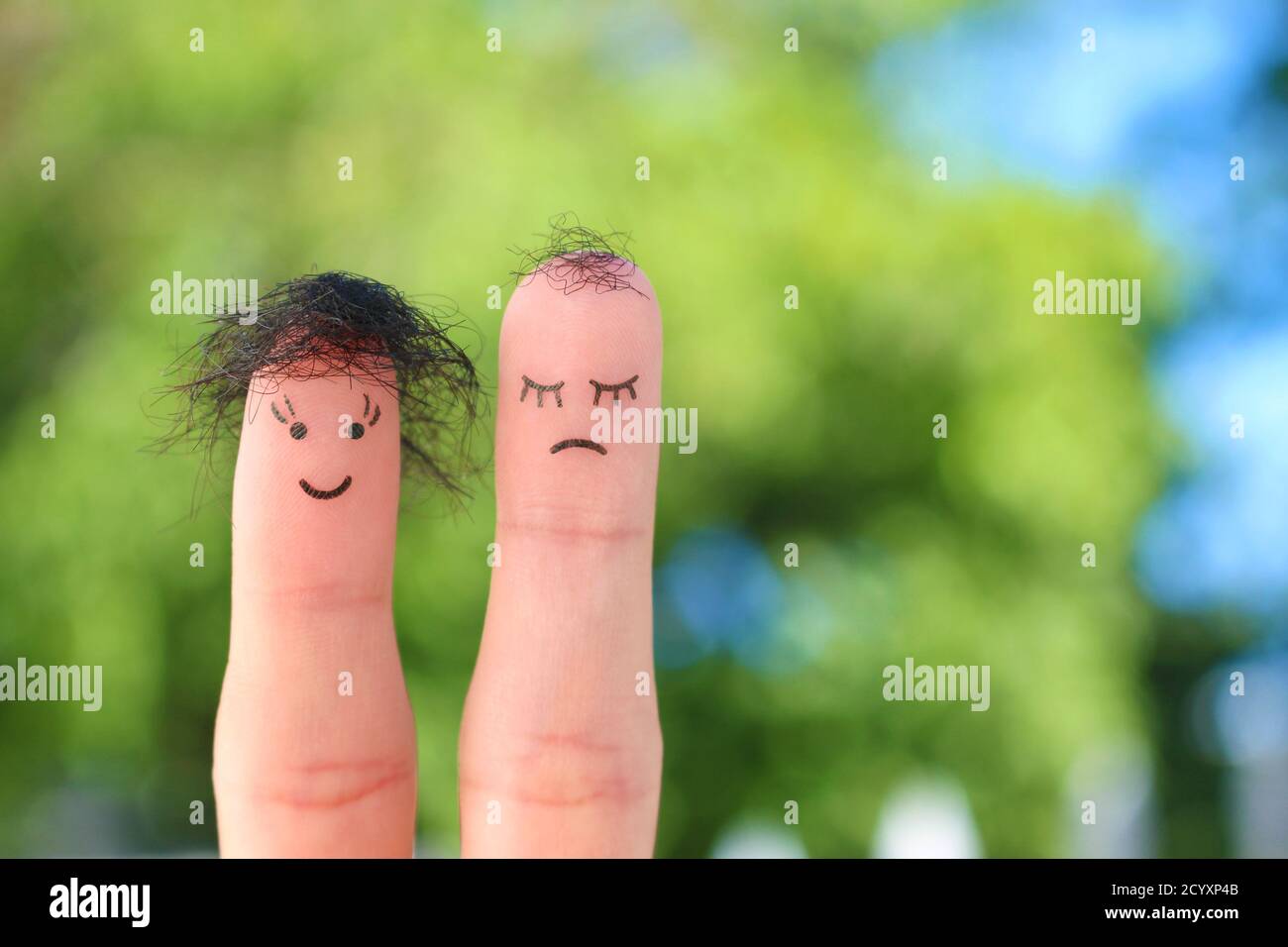 Fingers art of couple. This man is upset because he is bald. Stock Photo