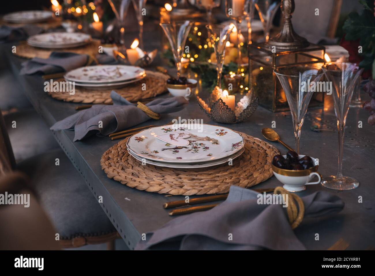 Christmas table with flowers, fruits, candles and glasses. Stock Photo