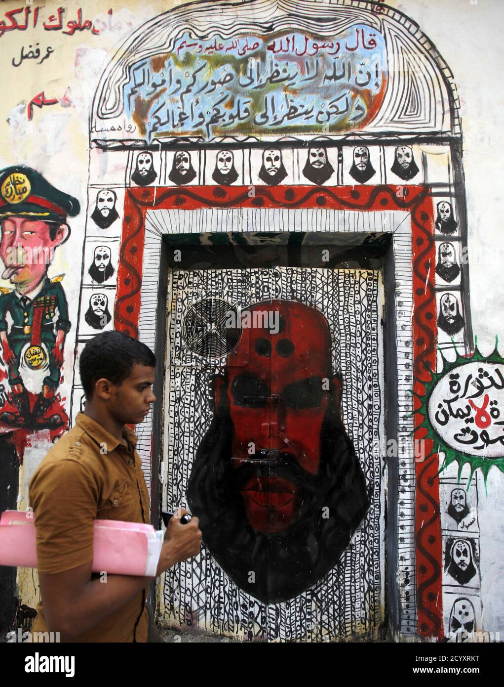 A man walks past a graffiti along Mohamed Mahmoud street near Tahrir Square  in Cairo September 26, 2012. The graffiti on the walls of Mohamed Mahmoud  Street had existed since November, where