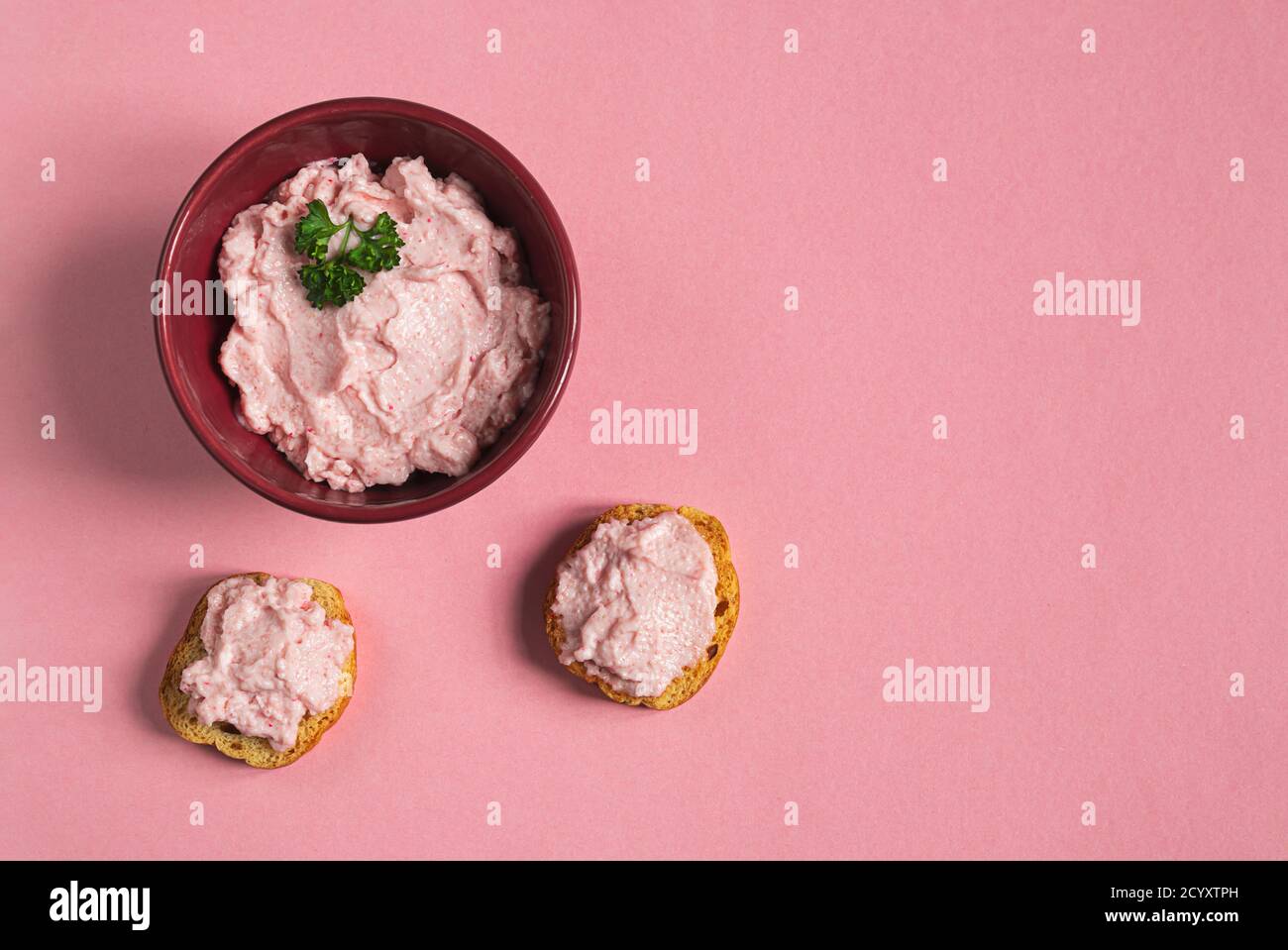 A bowl and crostini with tarama or taramasalata canape isolated on the pink background Stock Photo