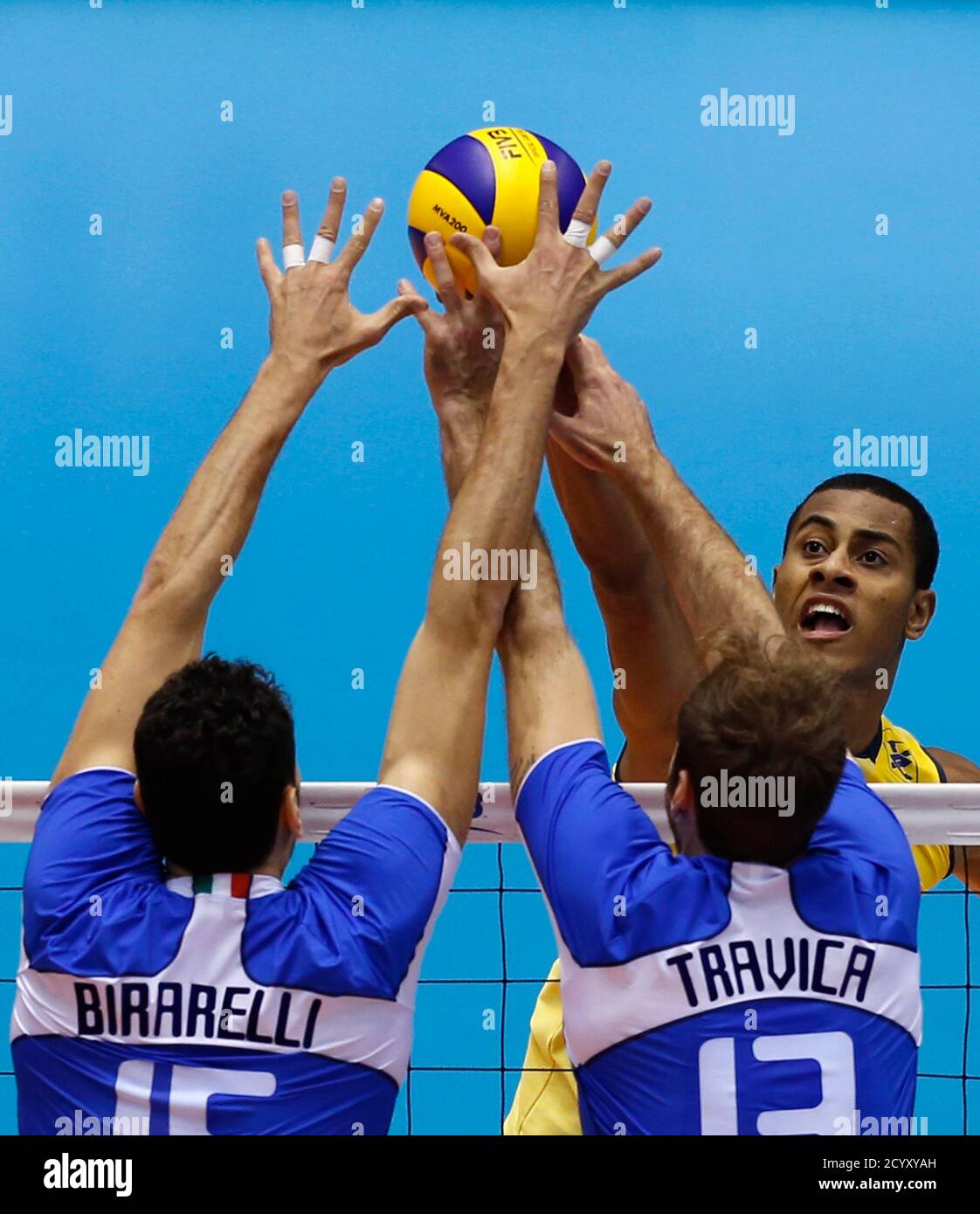 rem samen Prediken Ricardo Lucarelli Santos De Souza (back R) of Brazil pushes the ball  against Emanuele Birarelli (L) and Dragan Travica of Italy during their  FIVB Men's Volleyball World Grand Champions Cup 2013 in