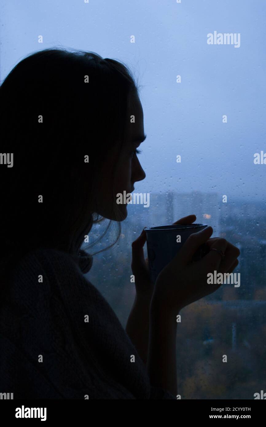 Silhouette Of A Young Beautiful Girl With A Cup Of Tea On A Window Background In A Cold Autumn Rainy Day Stock Photo Alamy Silhouette Of A Young Beautiful Girl With A Cup Of Tea On A Window Background In A Cold Autumn Rainy Day Stock Photo Alamy