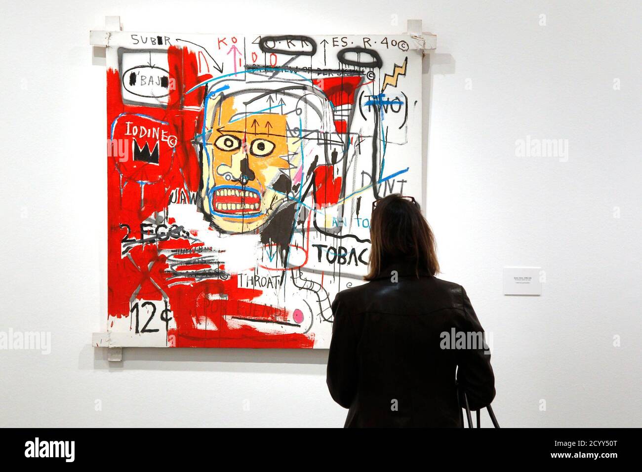 A visitor looks at the painting "Untitled, 1982-83" by U.S. artist  Jean-Michel Basquiat (1960-1988) before the opening of the exhibition  "Basquiat" at the Museum of Modern Art in Paris October 14, 2010.