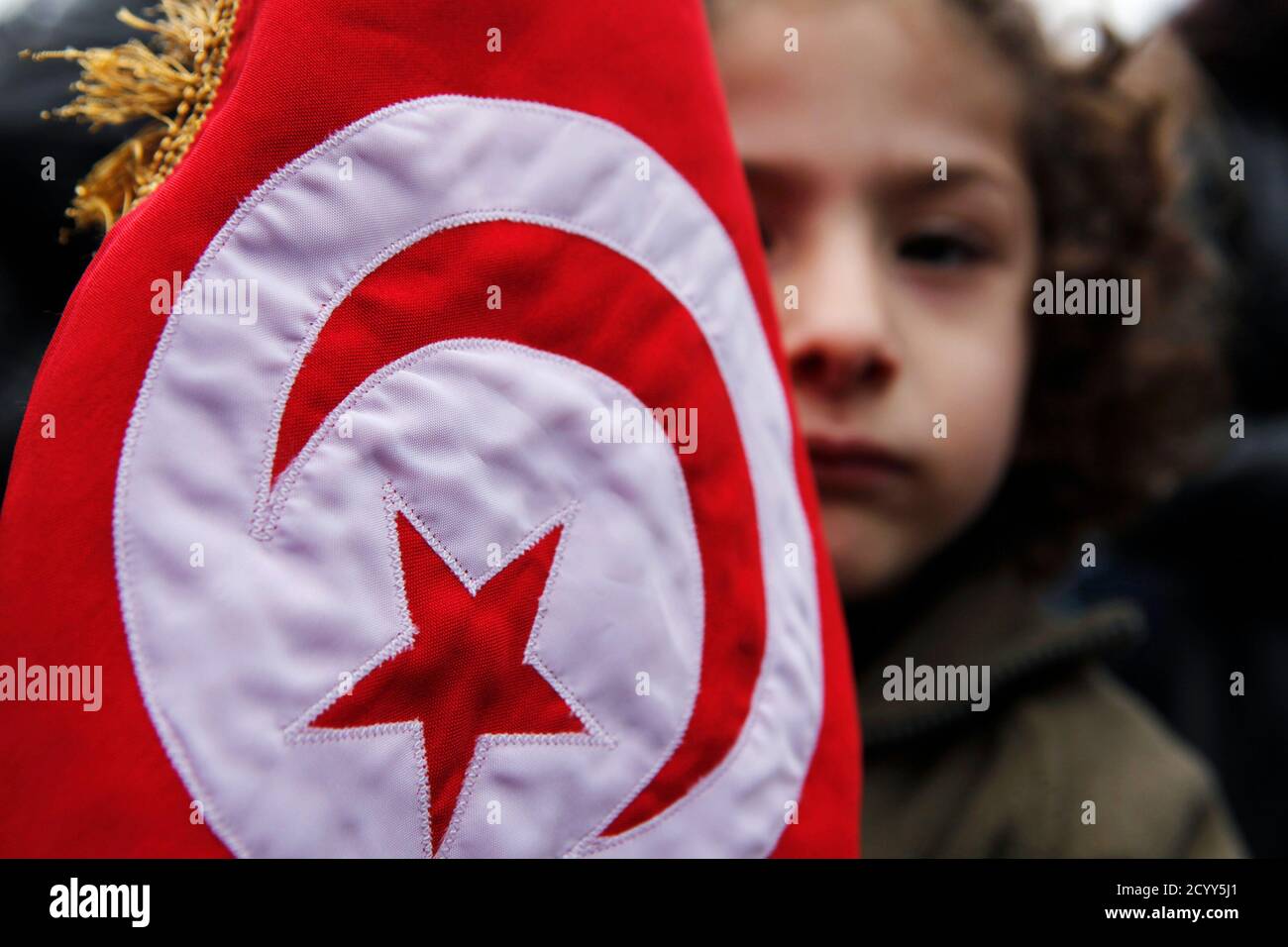A girl holds a Tunisian flag during a sit-in organized by Lebanese activists and Tunisian people living in Lebanon, in front of the U.N headquarters in Beirut, to show support for the Tunisian people, January 16, 2011.Tunisia's new leadership moved to form a coalition government to gain the upper hand over violent looters and quell arson and shooting that broke out after President Zine al-Abidine Ben Ali was ousted by protests. REUTERS/ Cynthia Karam   (LEBANON - Tags: POLITICS) Stock Photo