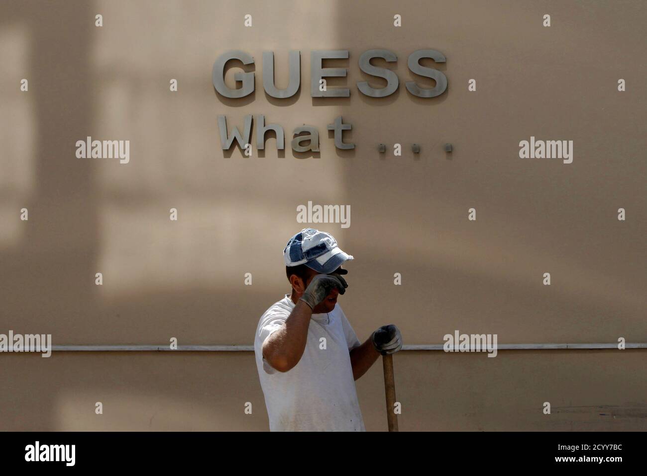 A construction worker wipes his face in the town of Thebes, about 88 km (55 miles) northwest of Athens, June 20, 2011. Contrasting fortunes tell the story of two Europes -- and the story of the euro itself. Euro zone membership plus low labour costs were supposed to be a winning combination for Greece.  In those early days of the common currency, Germany was the sick man of Europe, weighed down by the costs of reunification and an expensive labour market. Since then, rising labour costs in Greece have forced many manufacturers to shift to Asia or eastern Europe, or even to countries like Germa Stock Photo