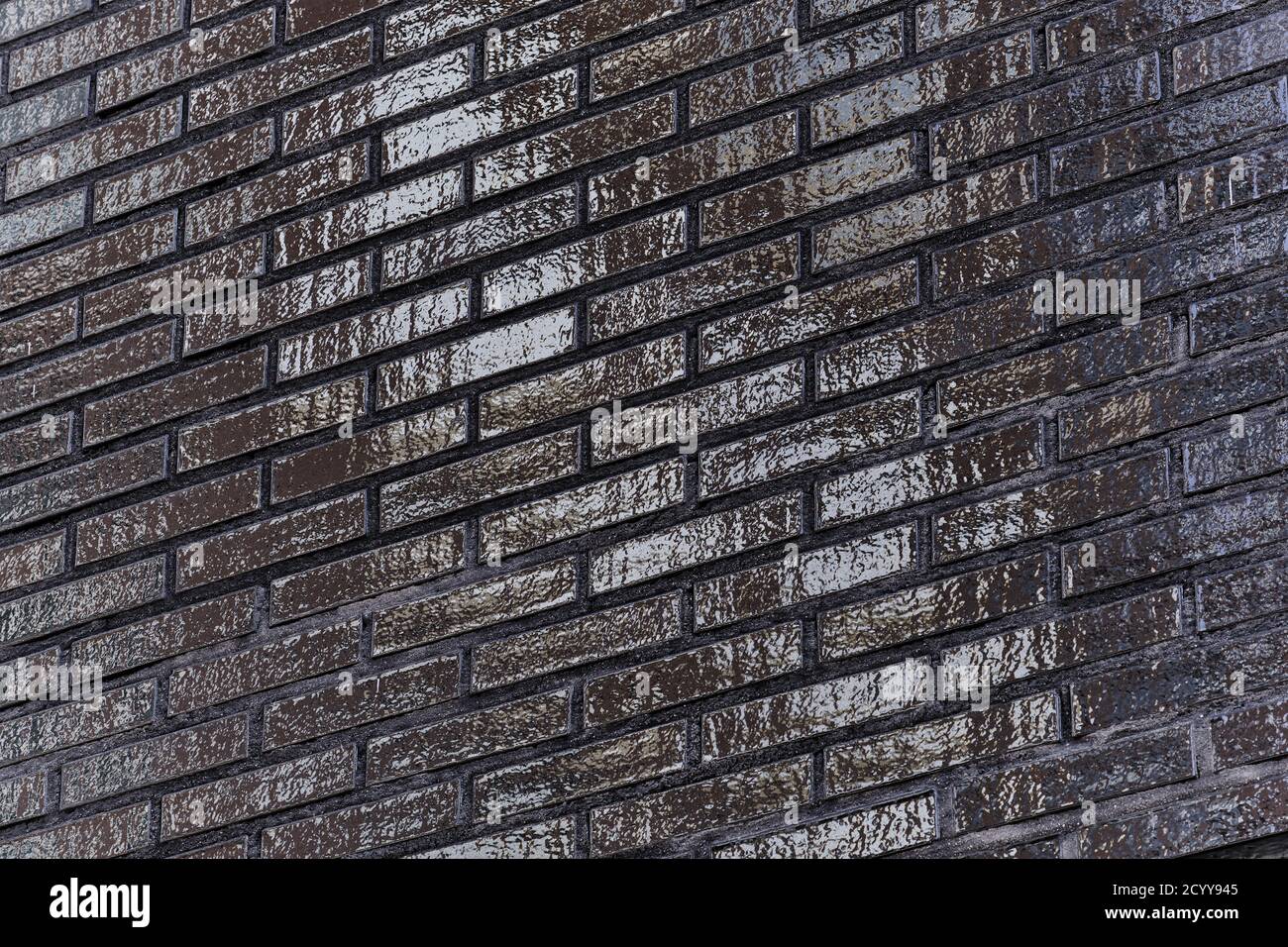 The black glossy brick wall of a modern apartment building. Modern nordic architecture. The
