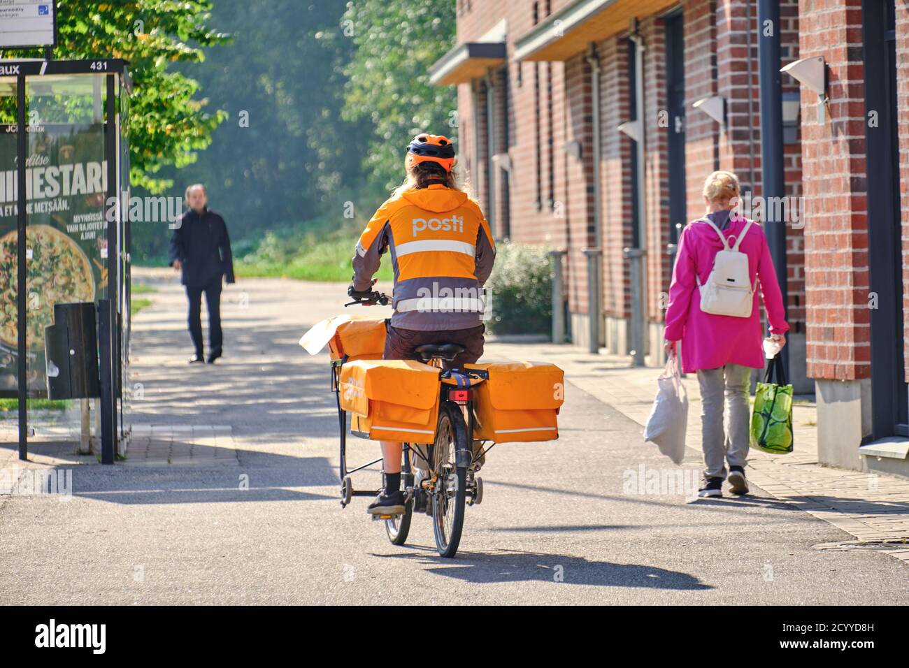 Espoo, Finland - September 24, 2020: The Finnish postman is riding the bike on the city street. Stock Photo