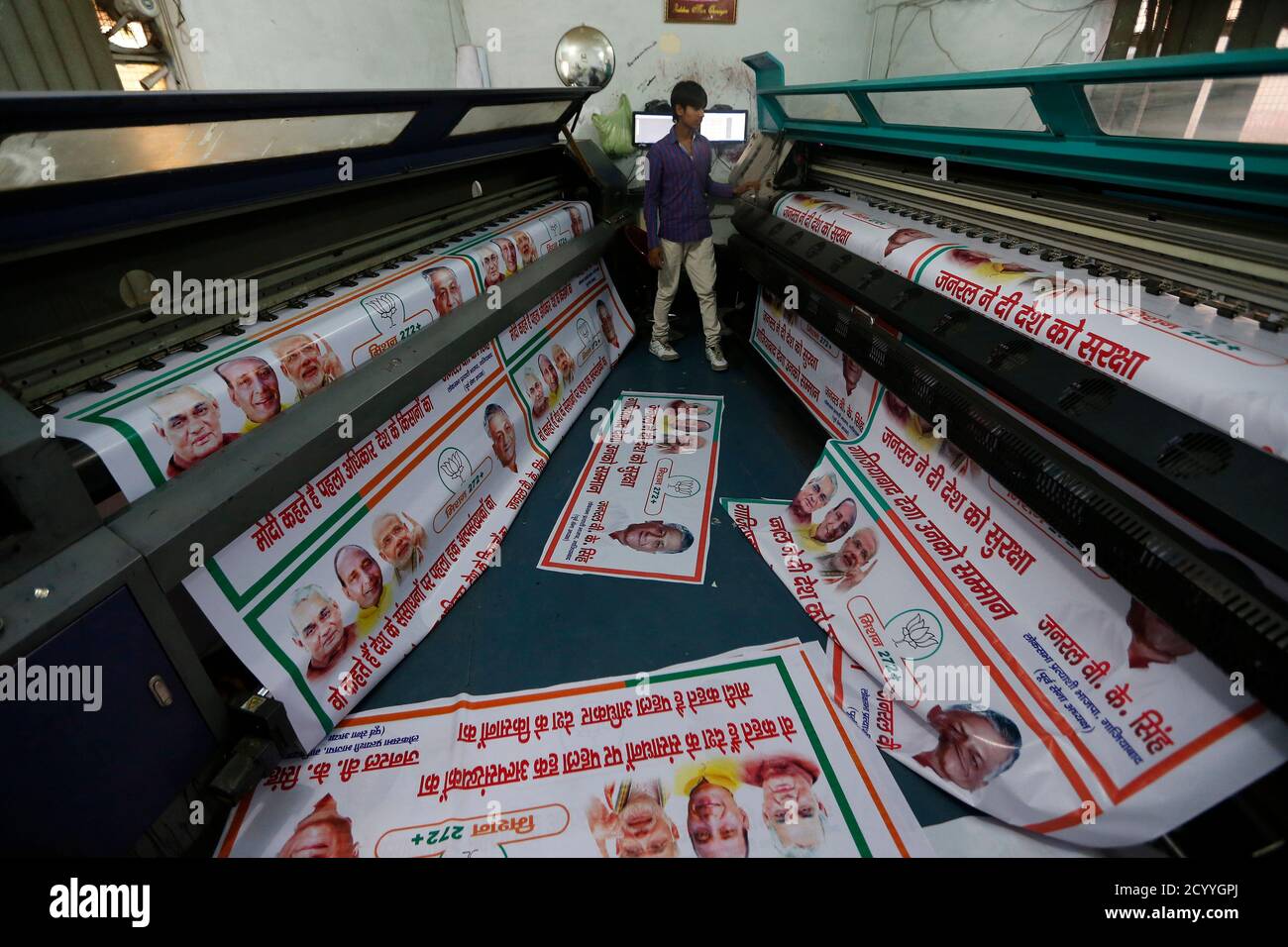 A worker operates a machine to print banners of India's main opposition Bharatiya  Janata Party (BJP) ahead of the 2014 general elections in Ghaziabad, on the  outskirts of New Delhi, March 24,
