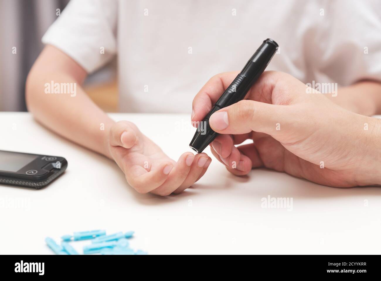 Young boy using checking blood sugar level. Diabetes and
