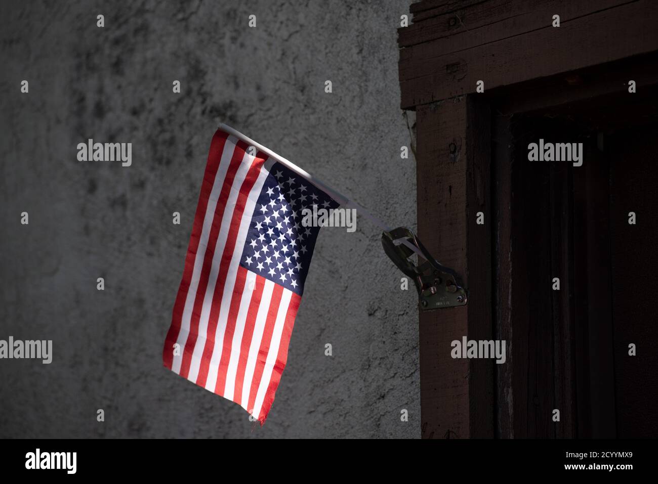 Upside-down American Flag in front of a poor house as a sign of political distress, as tensions grow with the approaching presidential election Stock Photo
