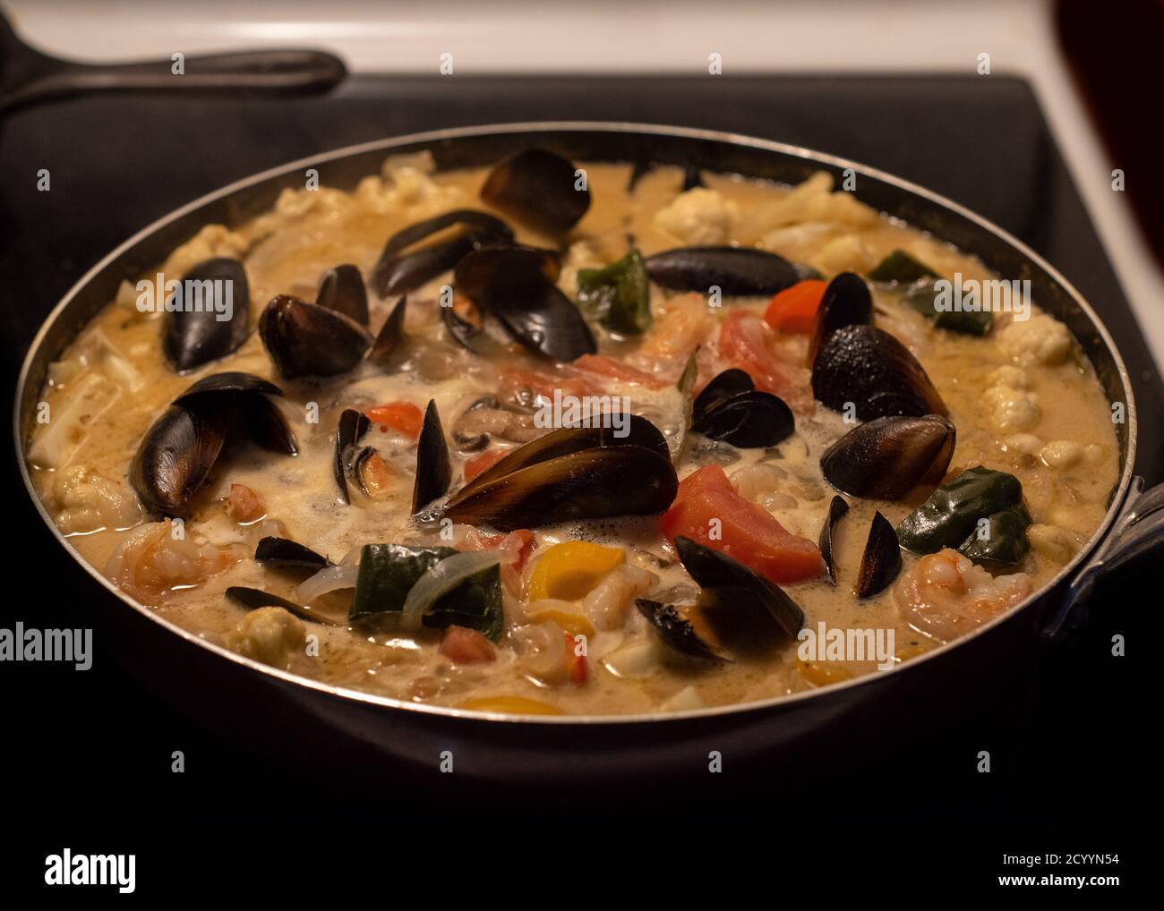 Clams stew being cooked on the stove top Stock Photo Alamy