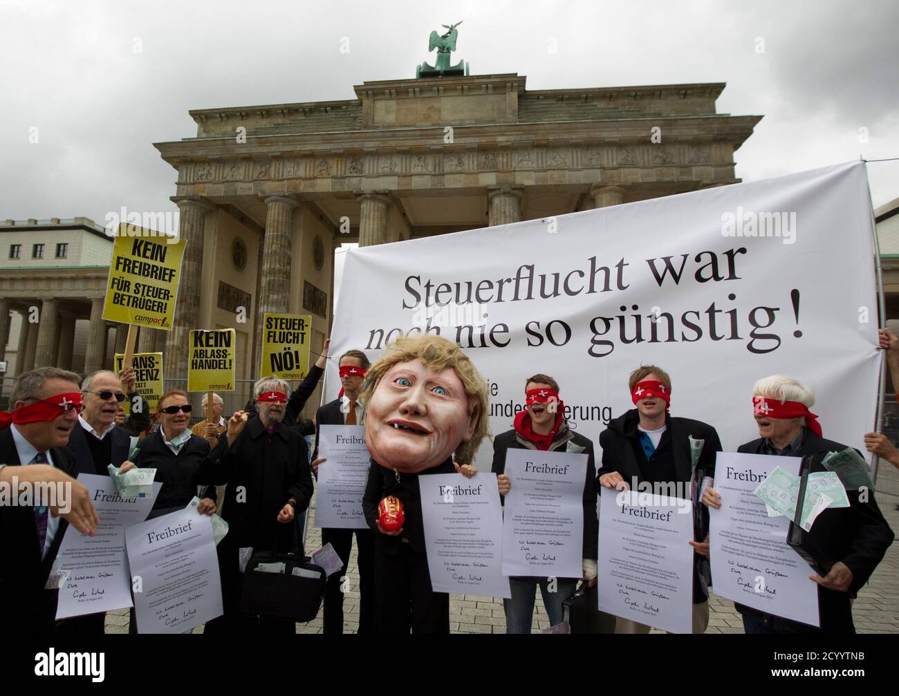 Activists from the "compact" group demonstrate against the new planned tax  agreement with Switzerland in front of the Brandenburg gate in Berlin,  August 10, 2011. The protester at centre wears a mask